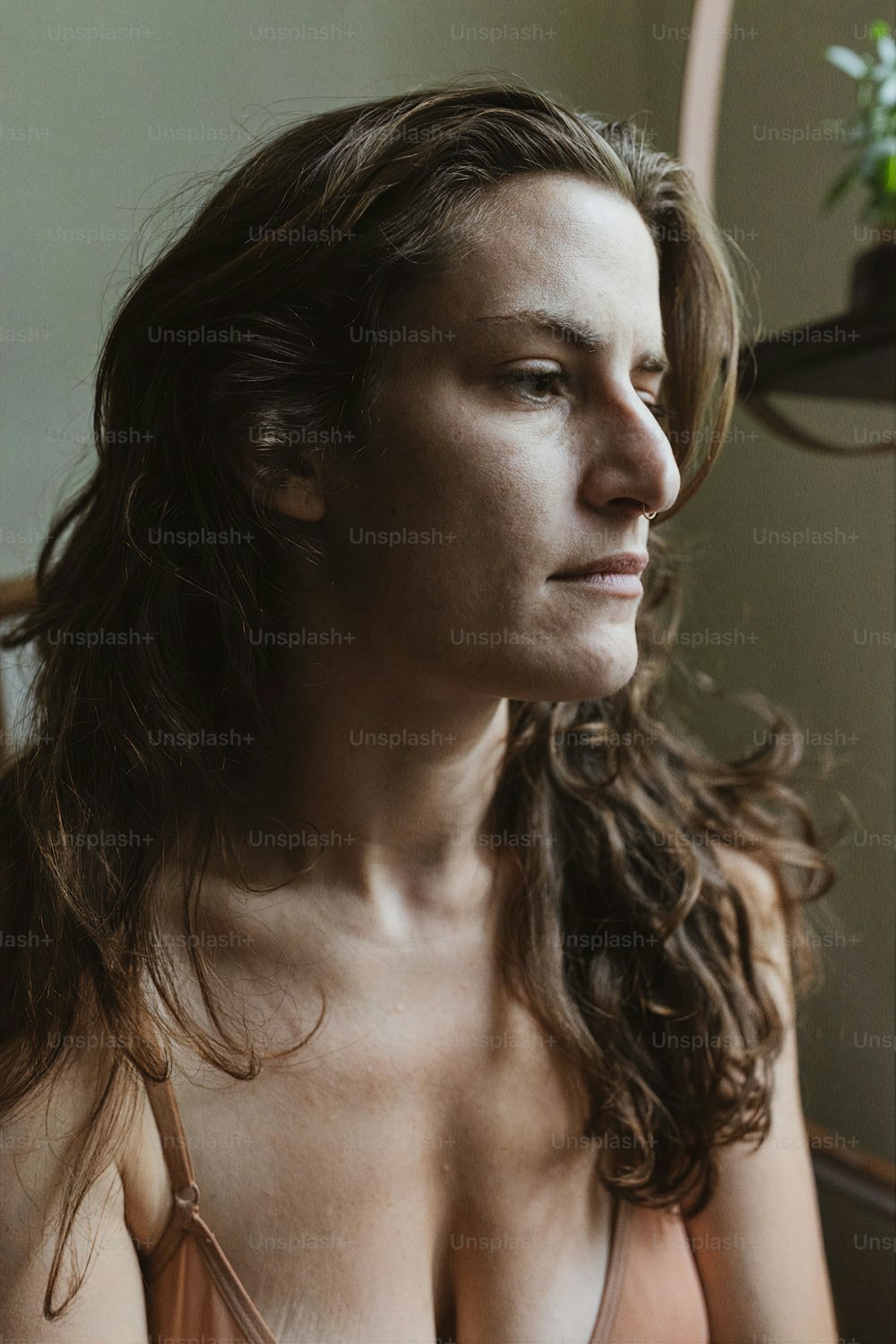 uma mulher em um sutiã olhando por uma janela