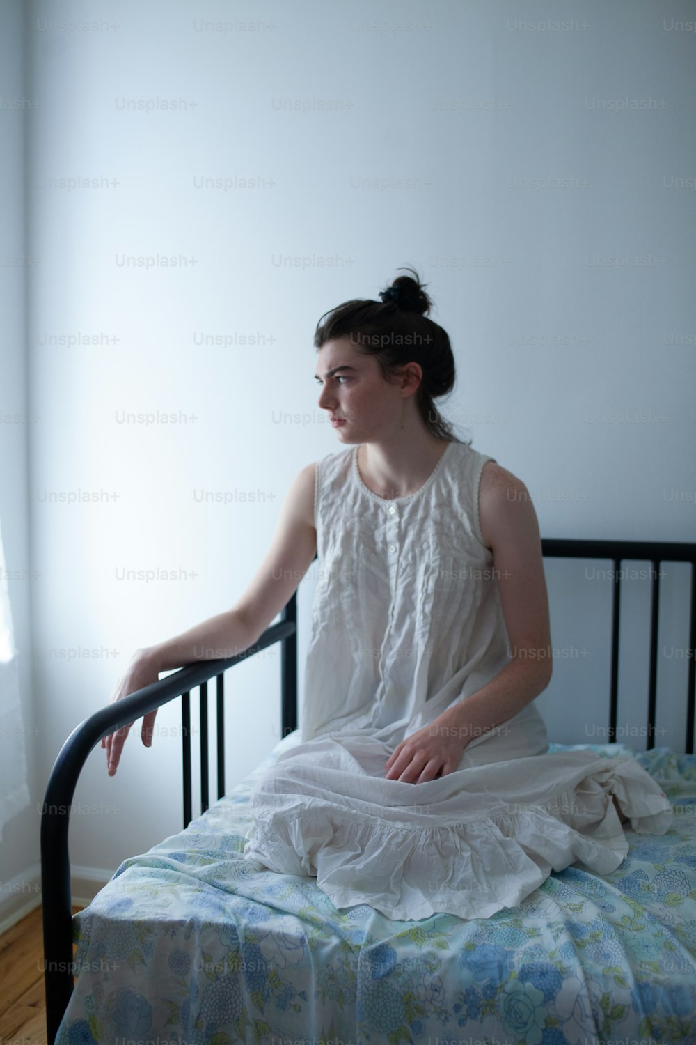 Una mujer sentada en una cama en una habitación
