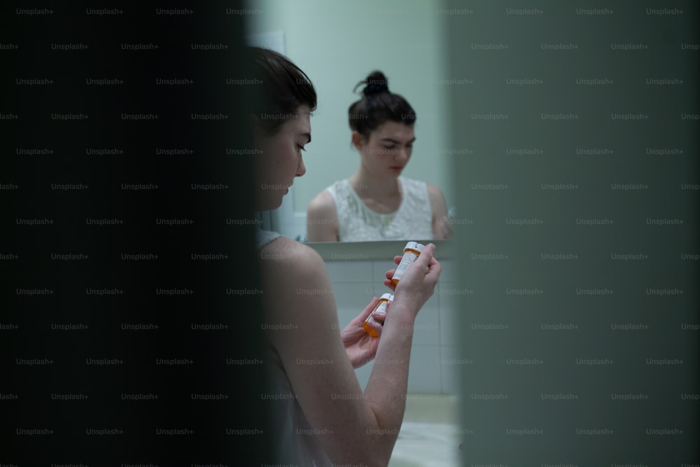 a woman brushing her teeth in front of a mirror