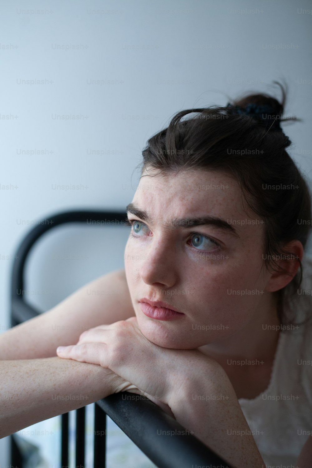 a woman leaning on a rail with her hand on her chin