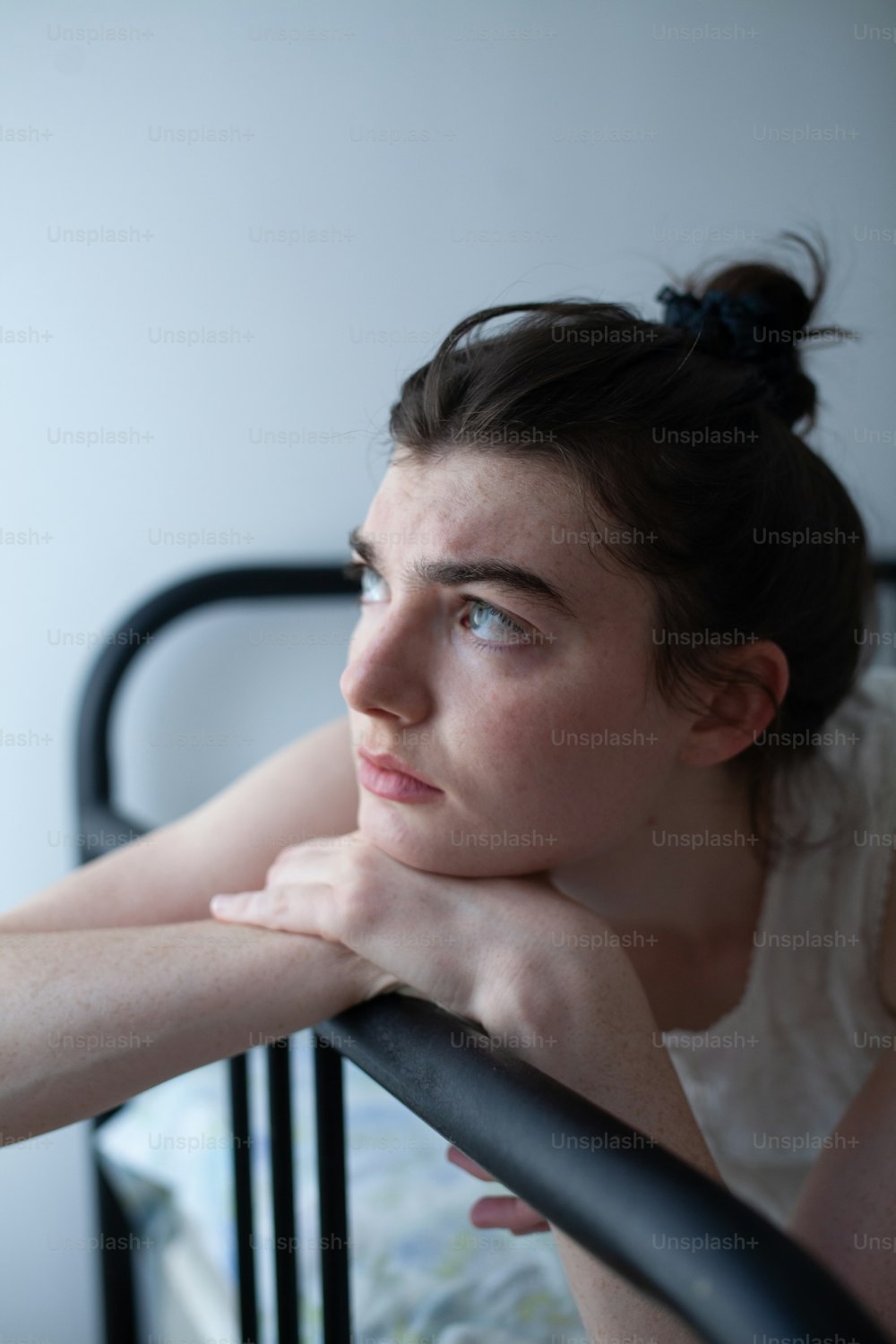 a woman leaning on a rail in a bedroom