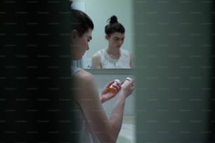 鏡の前で歯を磨く女性