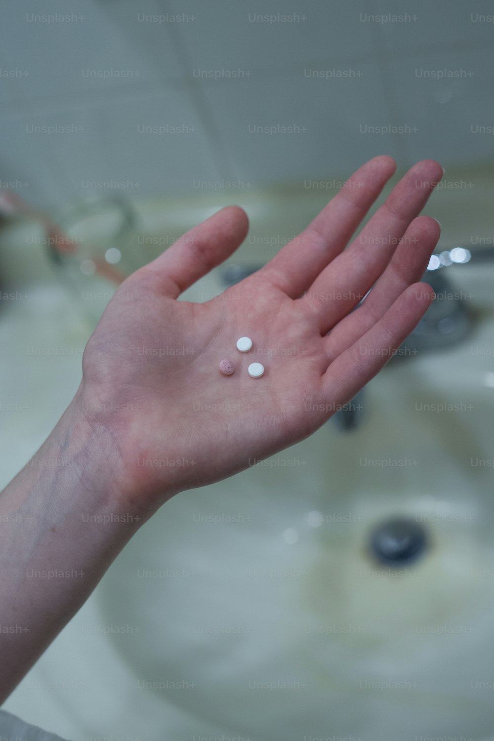 a person holding their hand out with a lot of pills on it