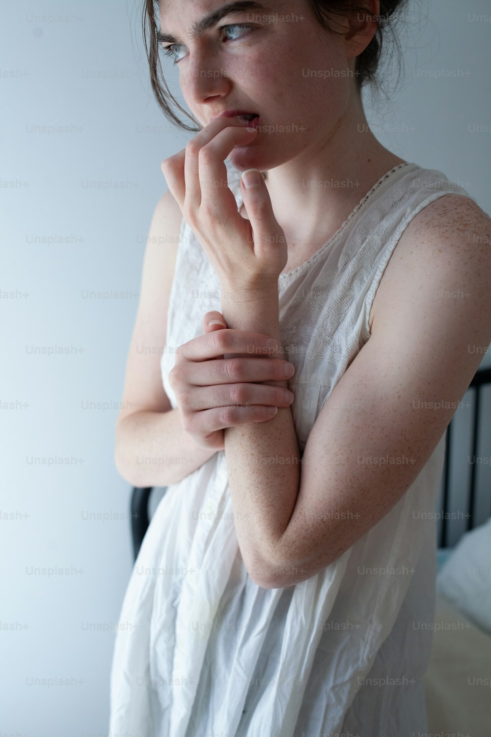 a woman in a white dress holding her hands together