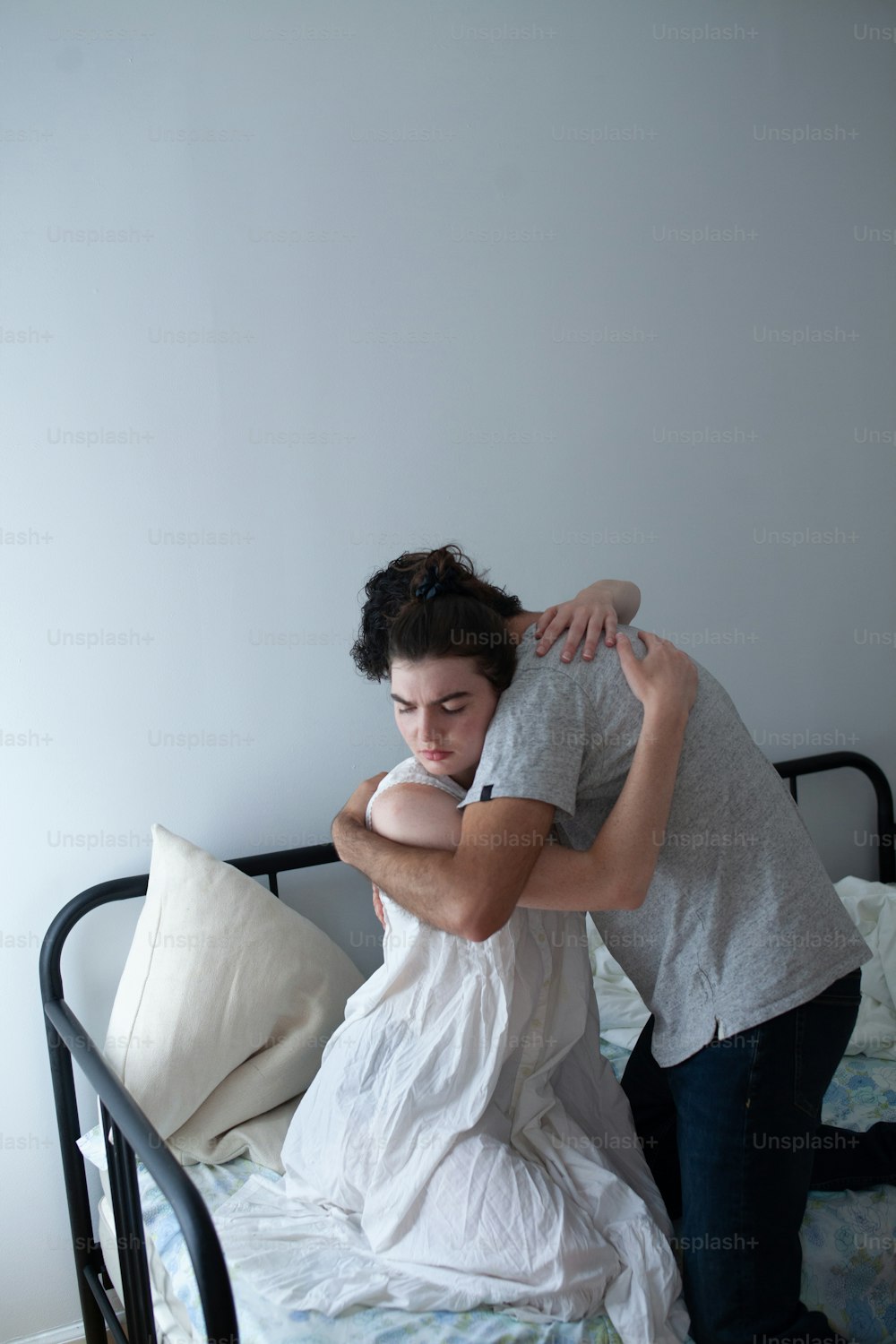 um homem abraçando uma mulher em cima de uma cama