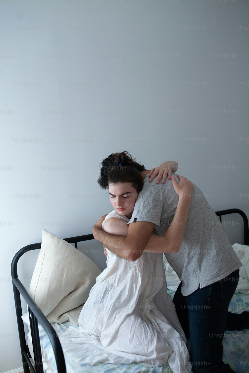a man hugging a woman on top of a bed