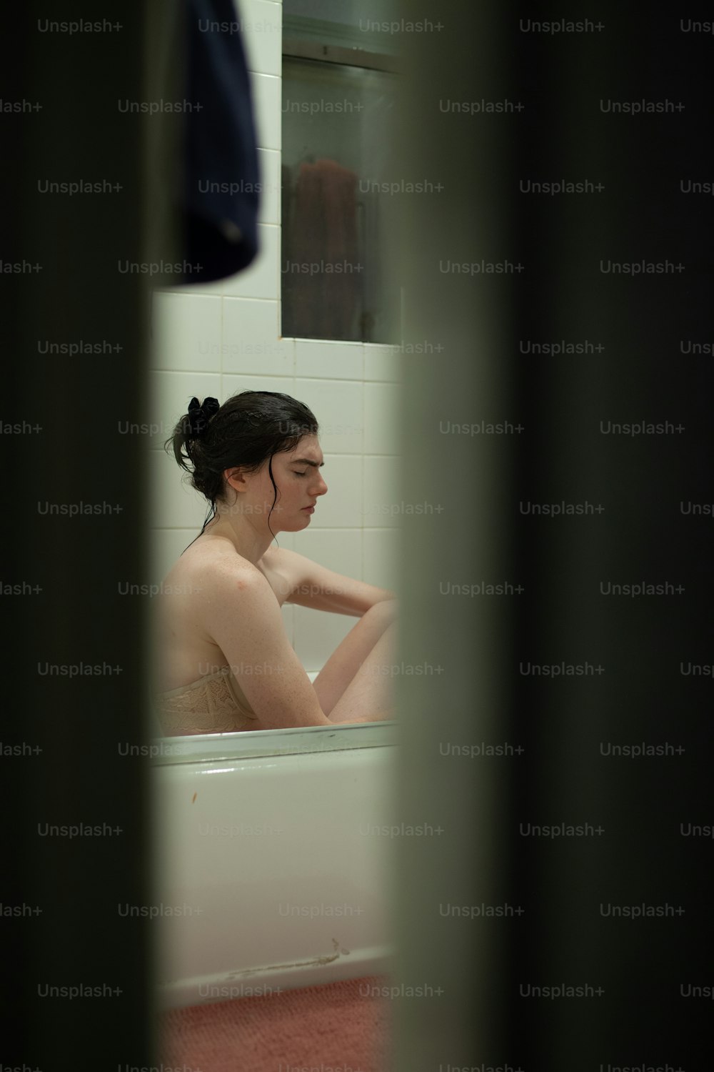 Una mujer sentada en una bañera en un baño