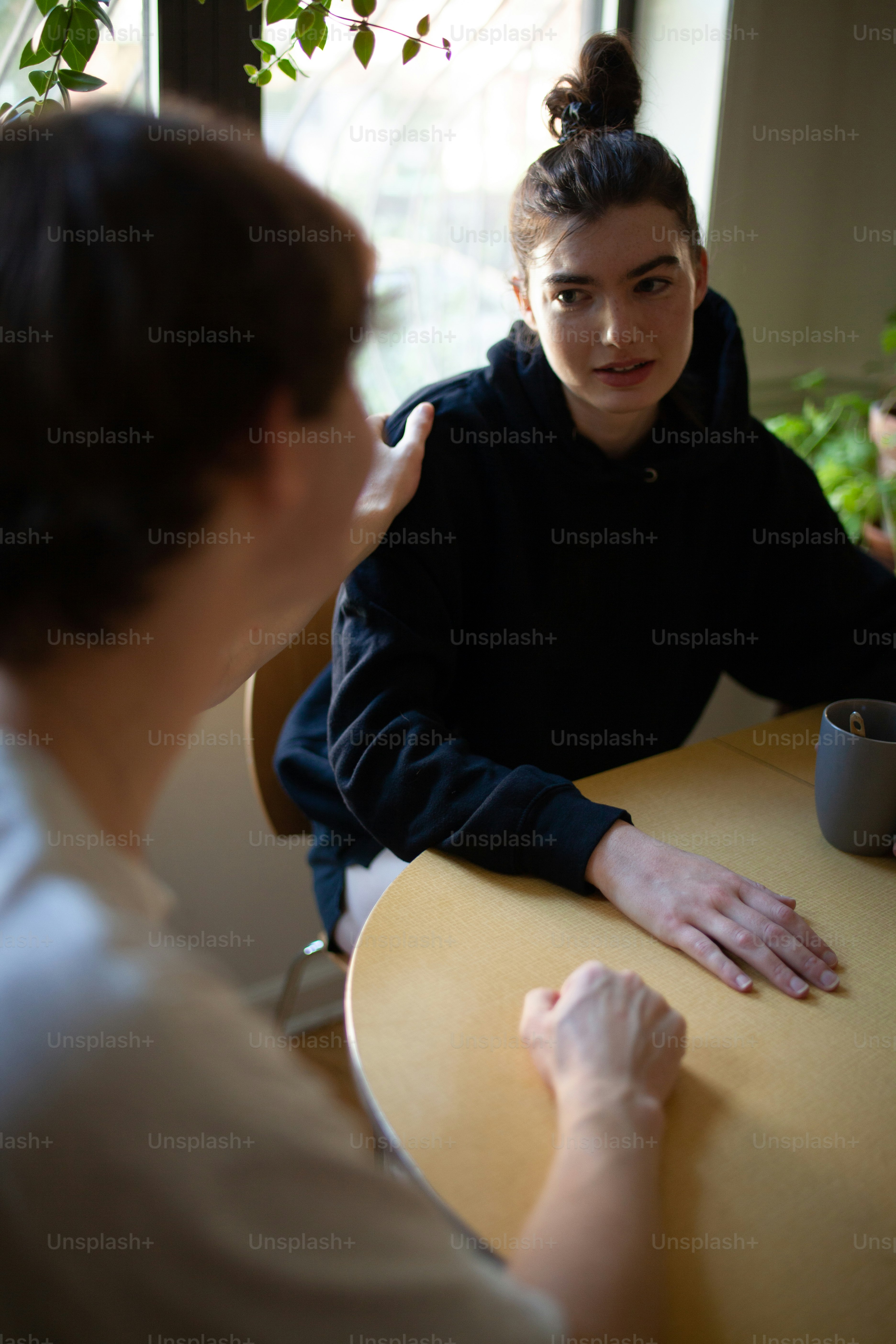 a woman sitting at a table with a cup of coffee