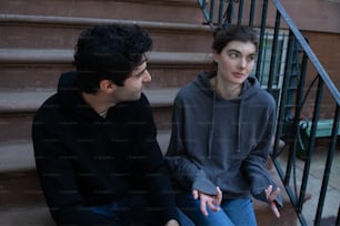a man sitting next to a woman on the steps