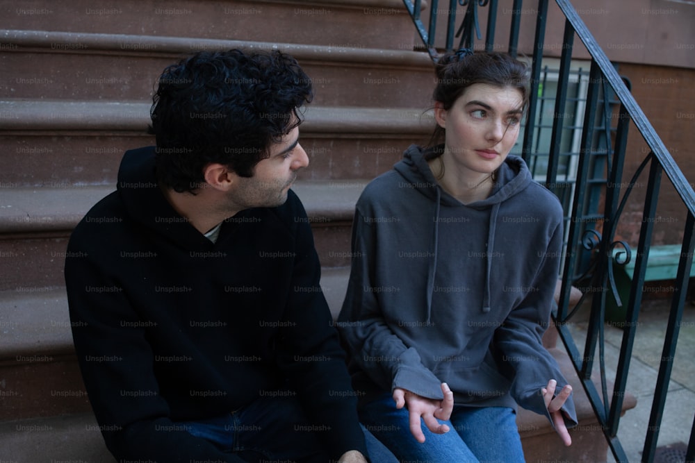 a man sitting next to a woman on the steps