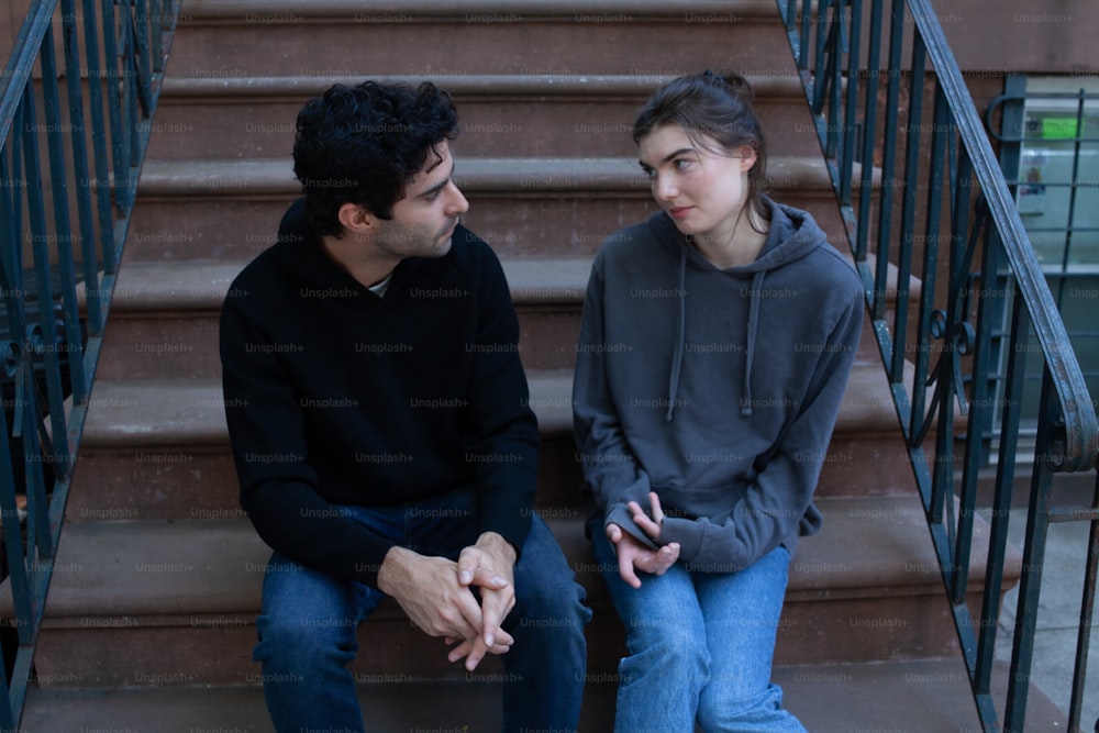 a man and a woman sitting on a set of stairs