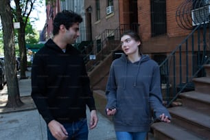 a man standing next to a woman on a sidewalk