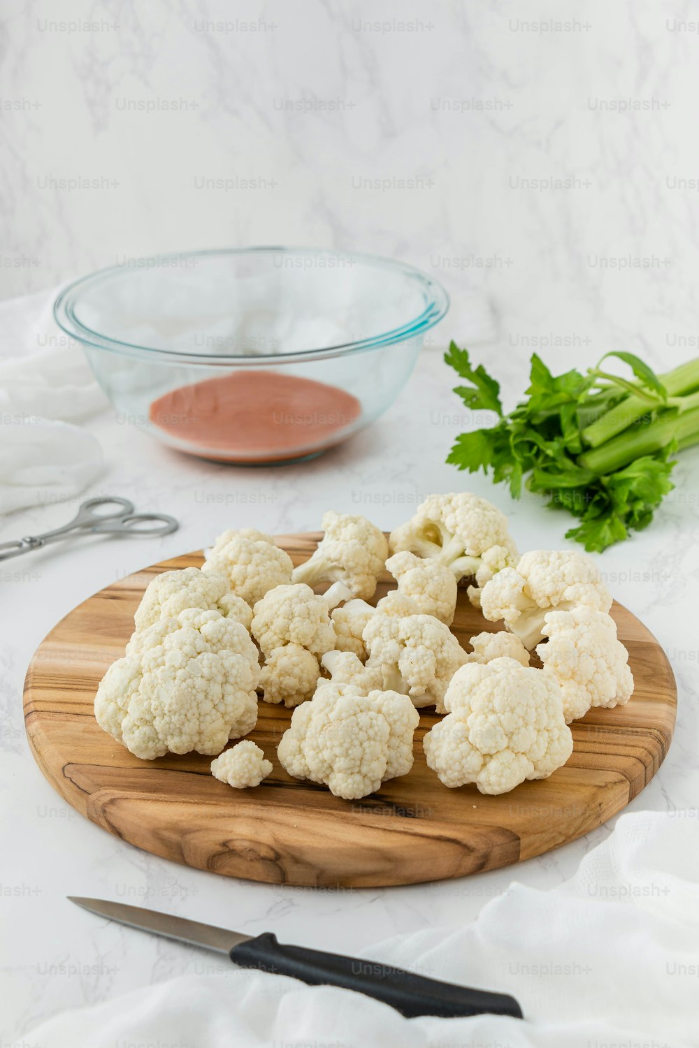 cauliflower on a cutting board next to a bowl of sauce
