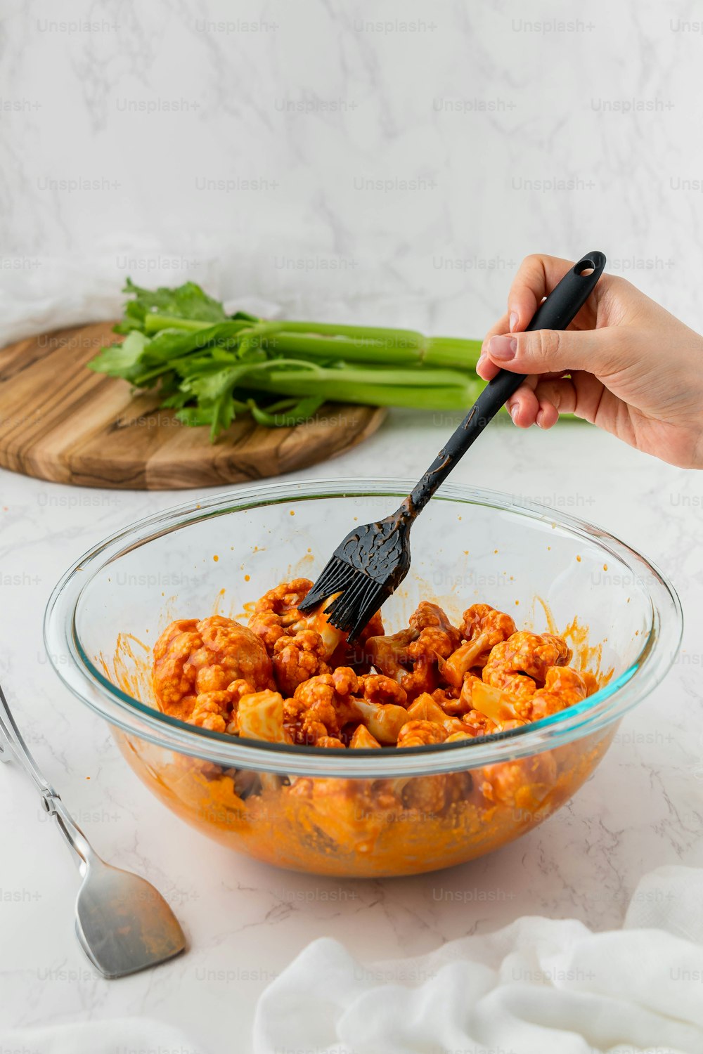 a person holding a spatula in a bowl of food