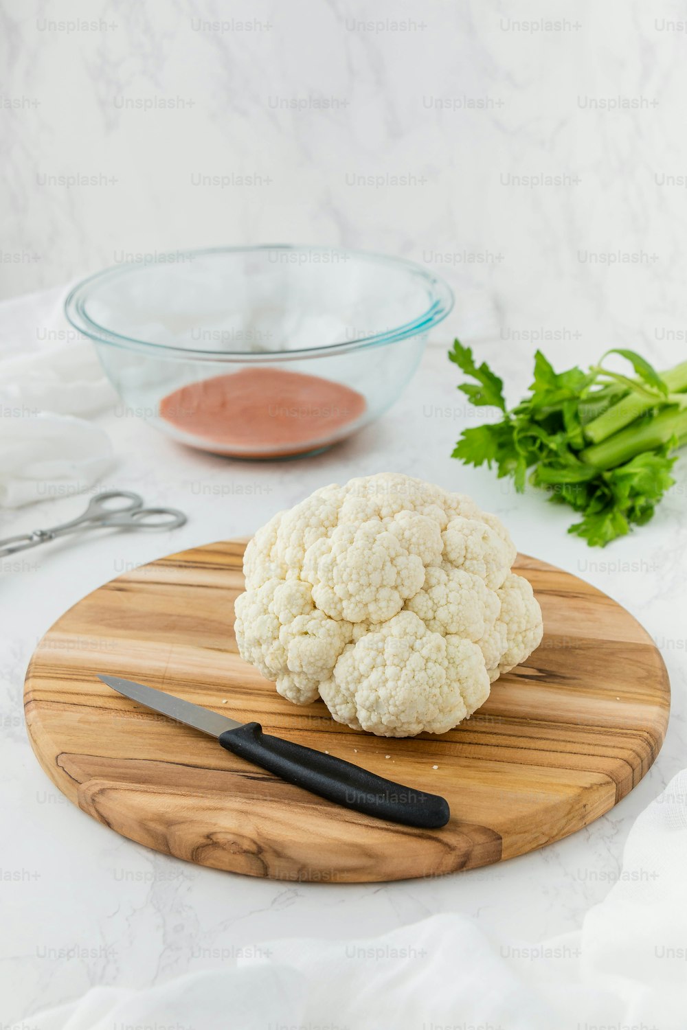 cauliflower on a cutting board next to a knife