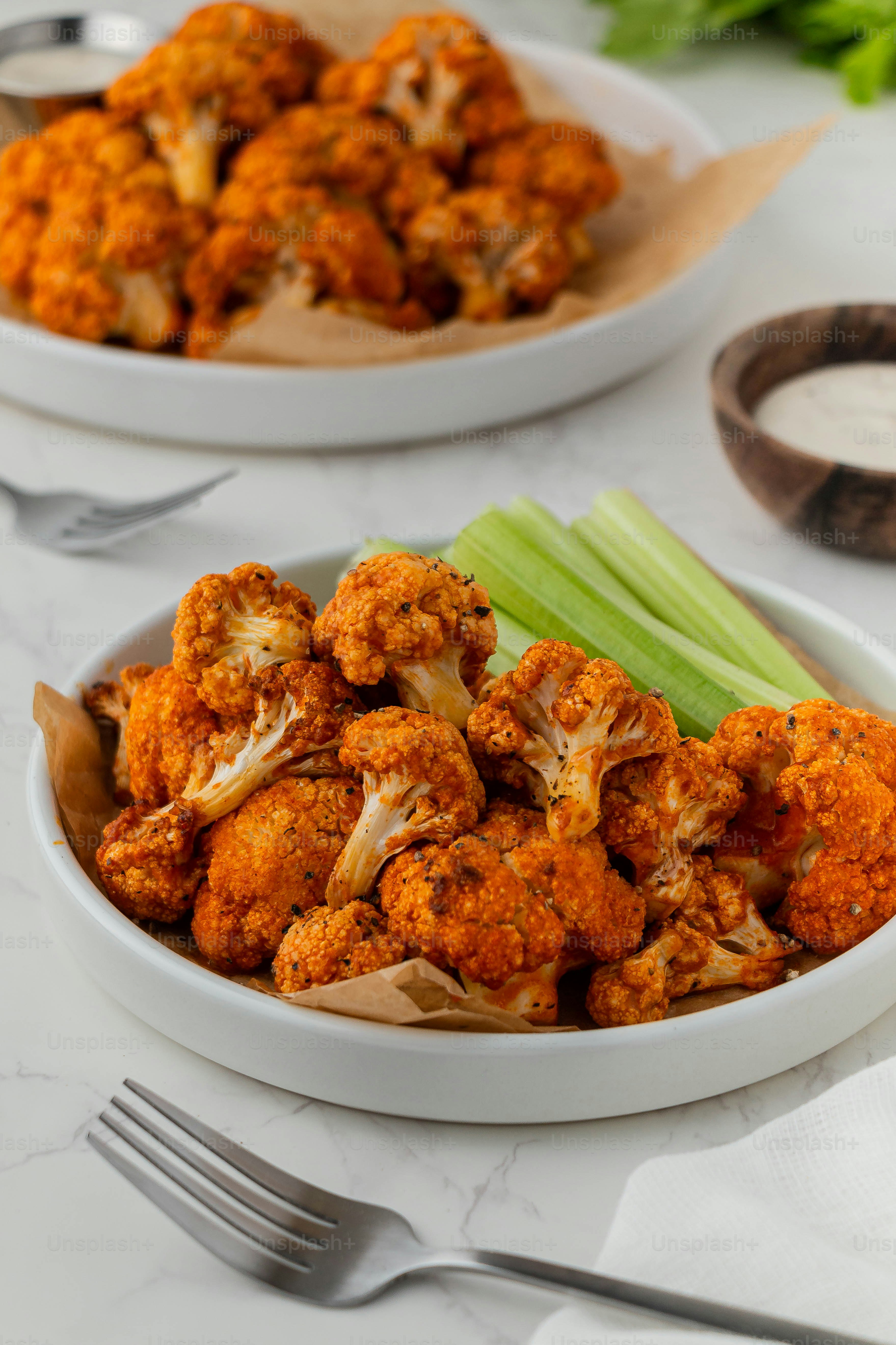 una ciotola piena di cavolfiore accanto a un piatto di sedano