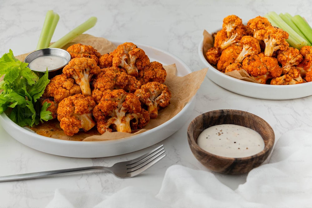 a bowl of cauliflower next to a bowl of celery