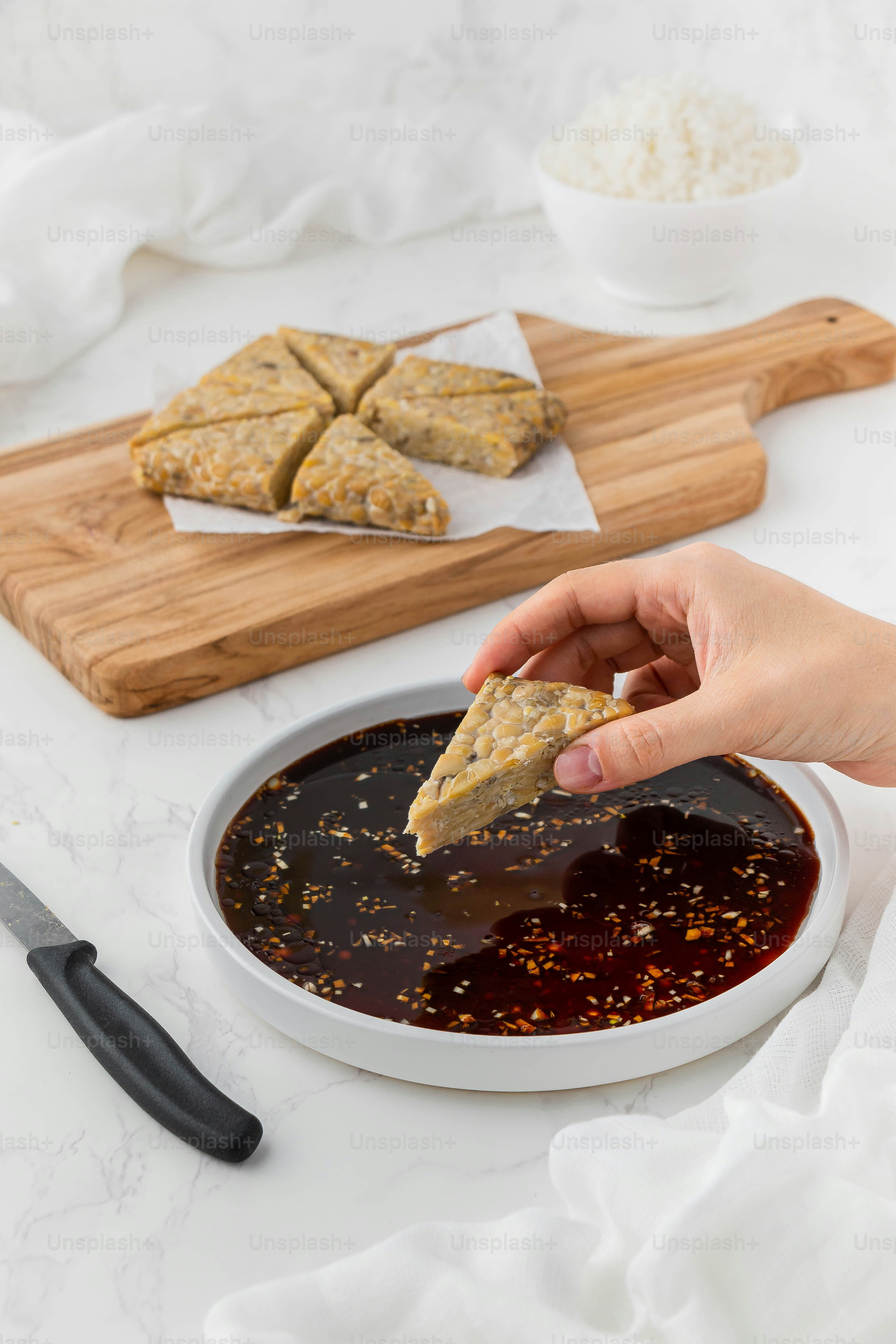 a person dipping some food into a bowl