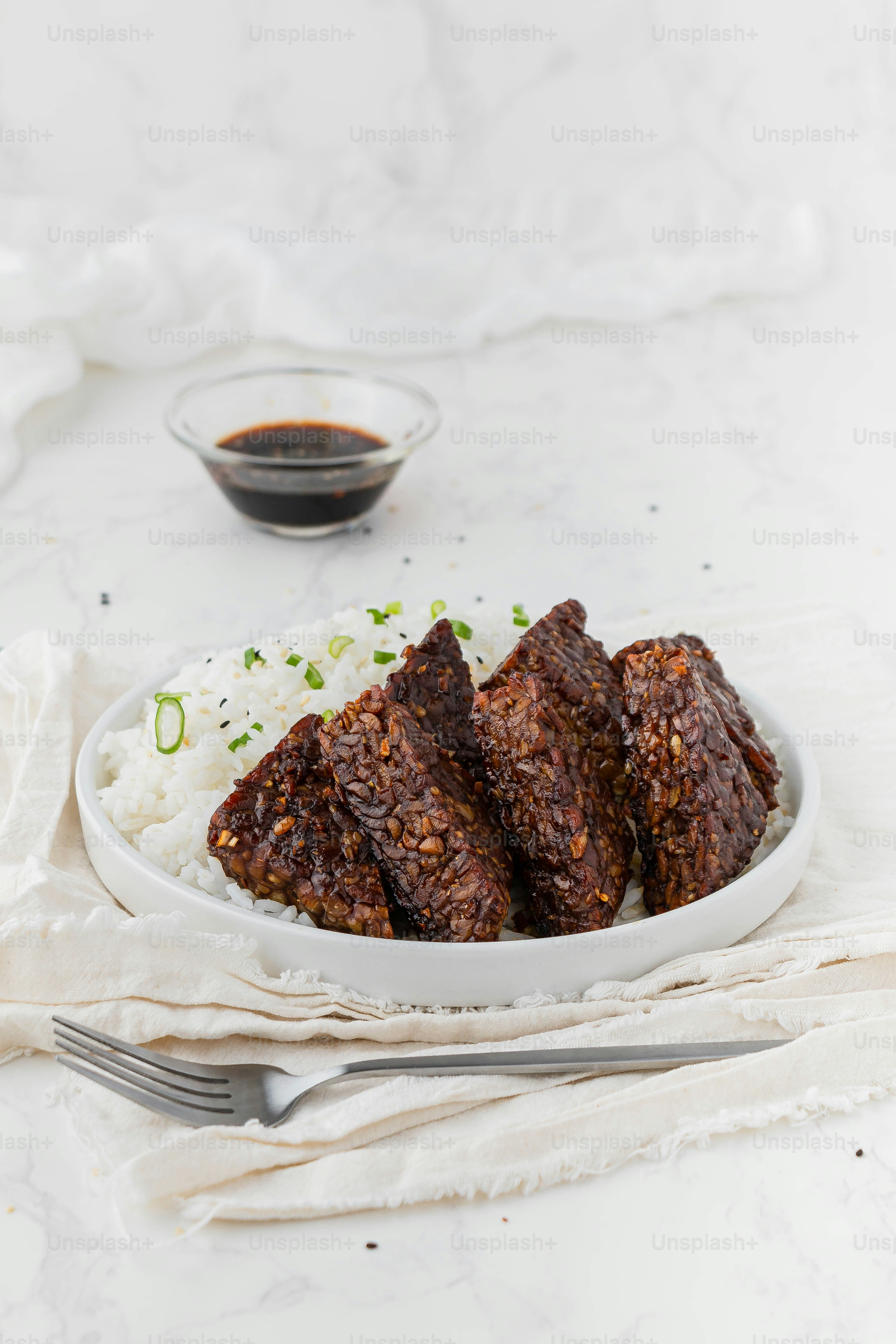 a white plate topped with meat and rice