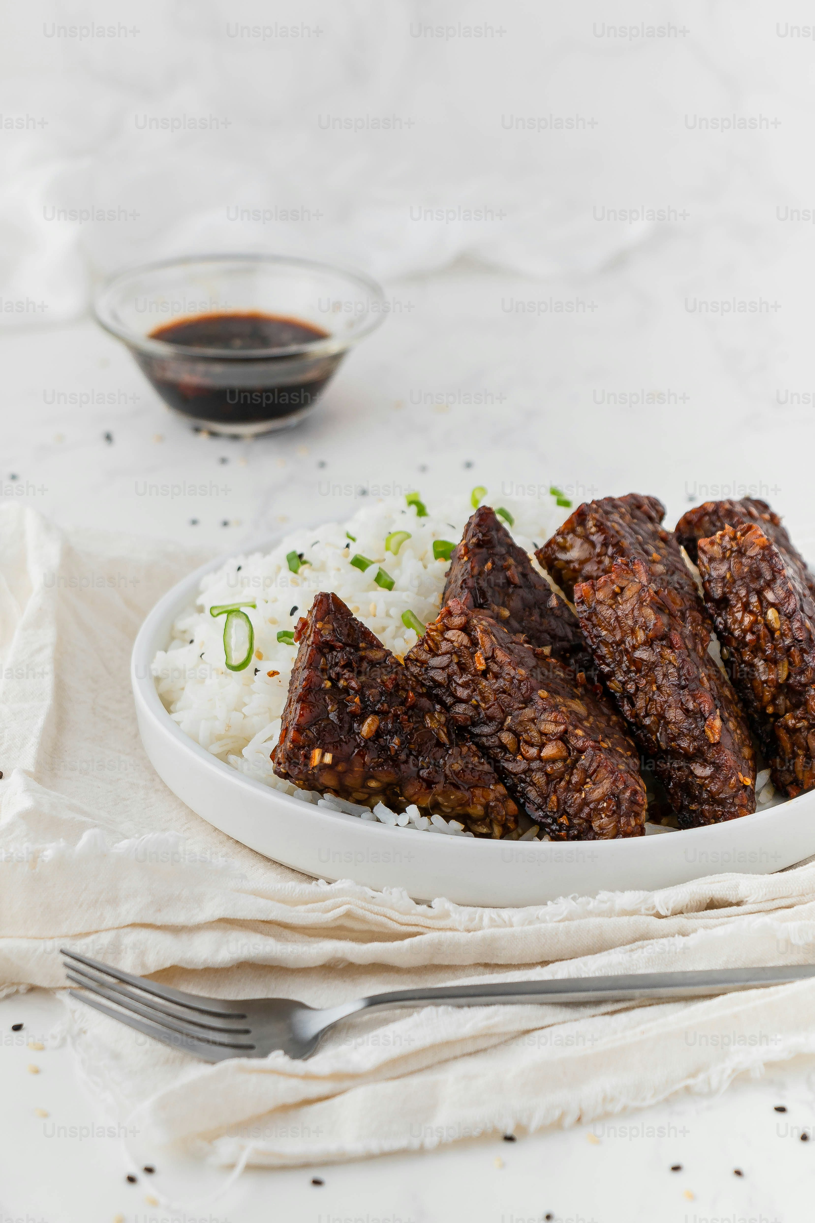 a white plate topped with meat and rice