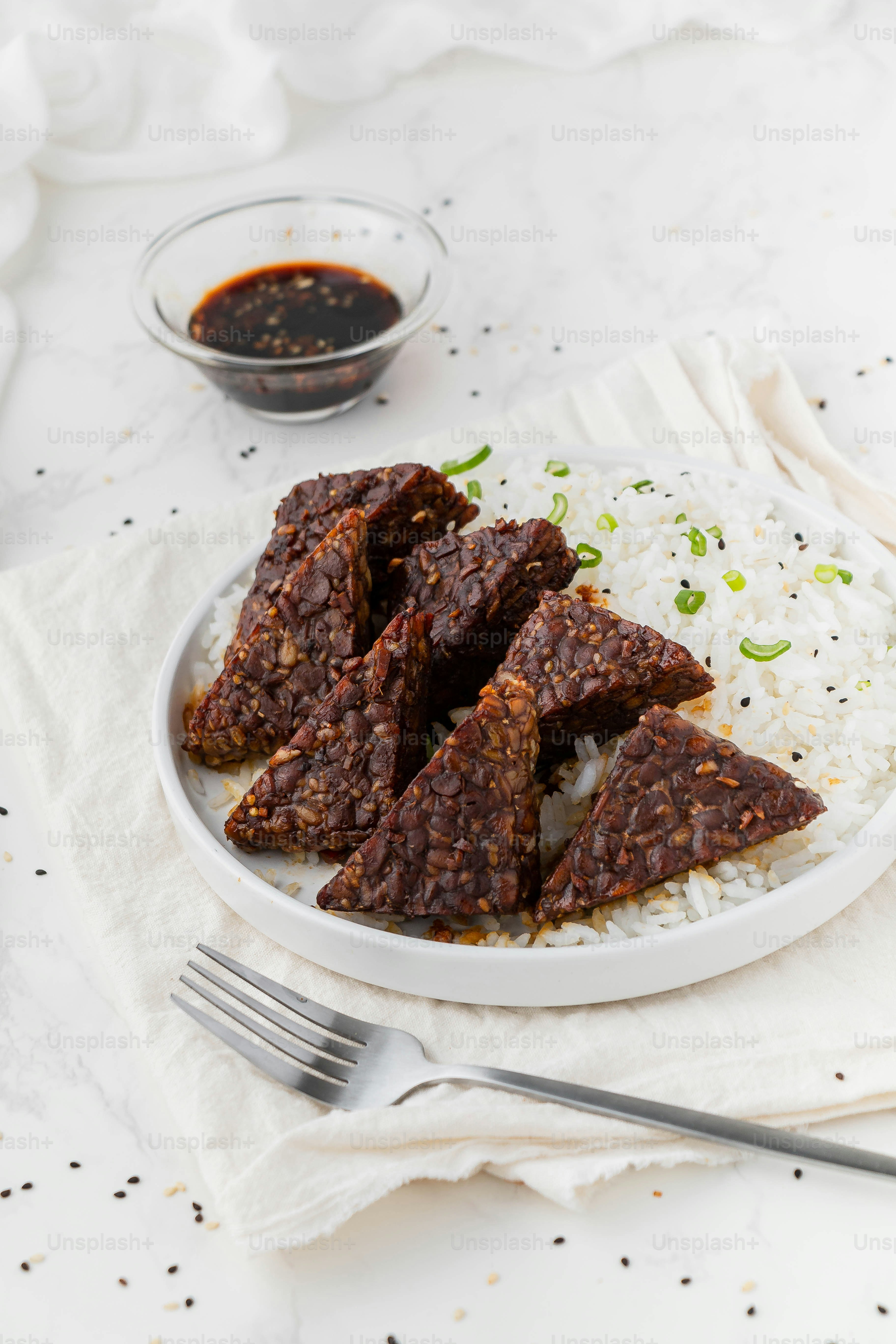 a white plate topped with meat and rice