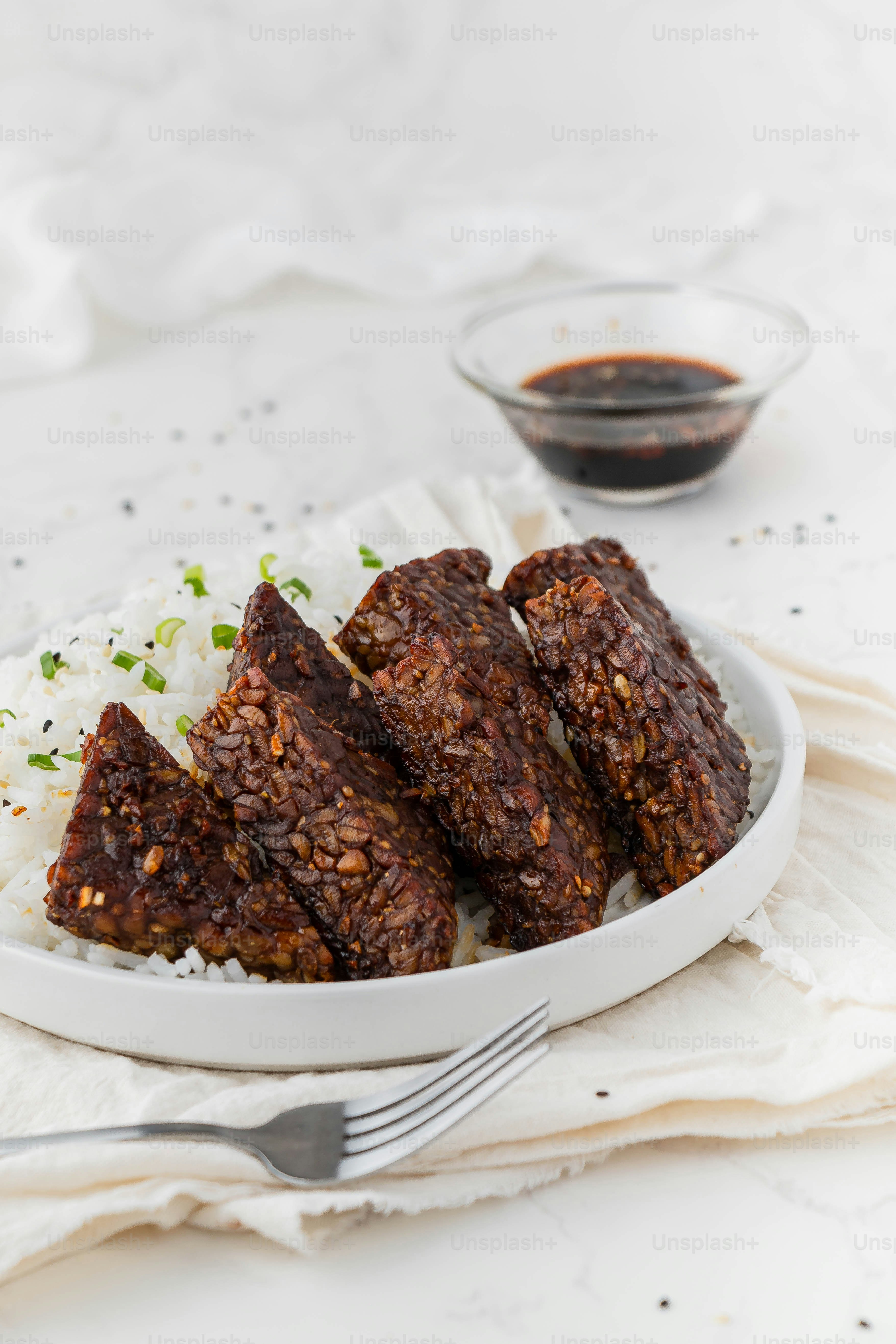 a white plate topped with meat and rice