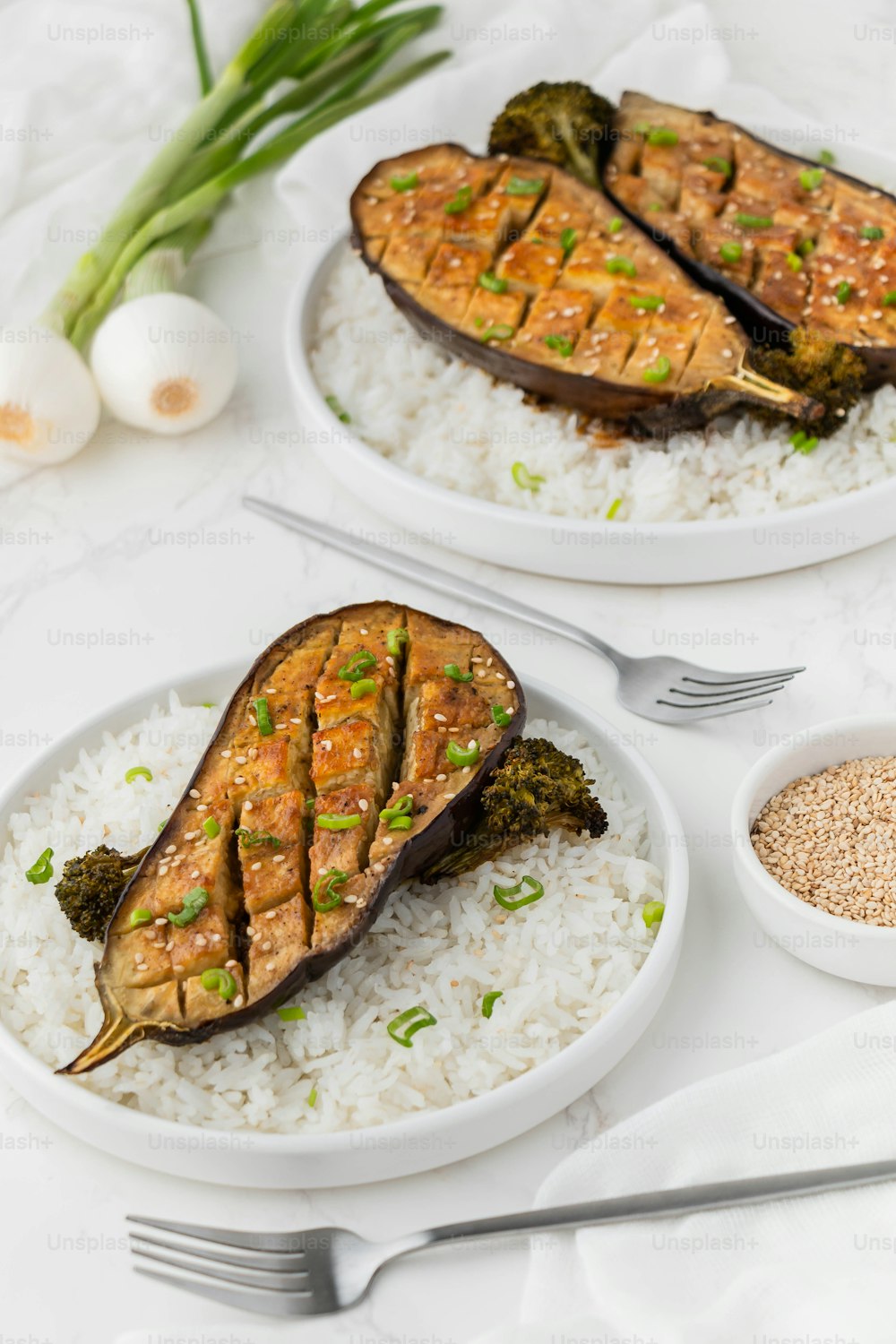 Dos platos de comida en una mesa con utensilios