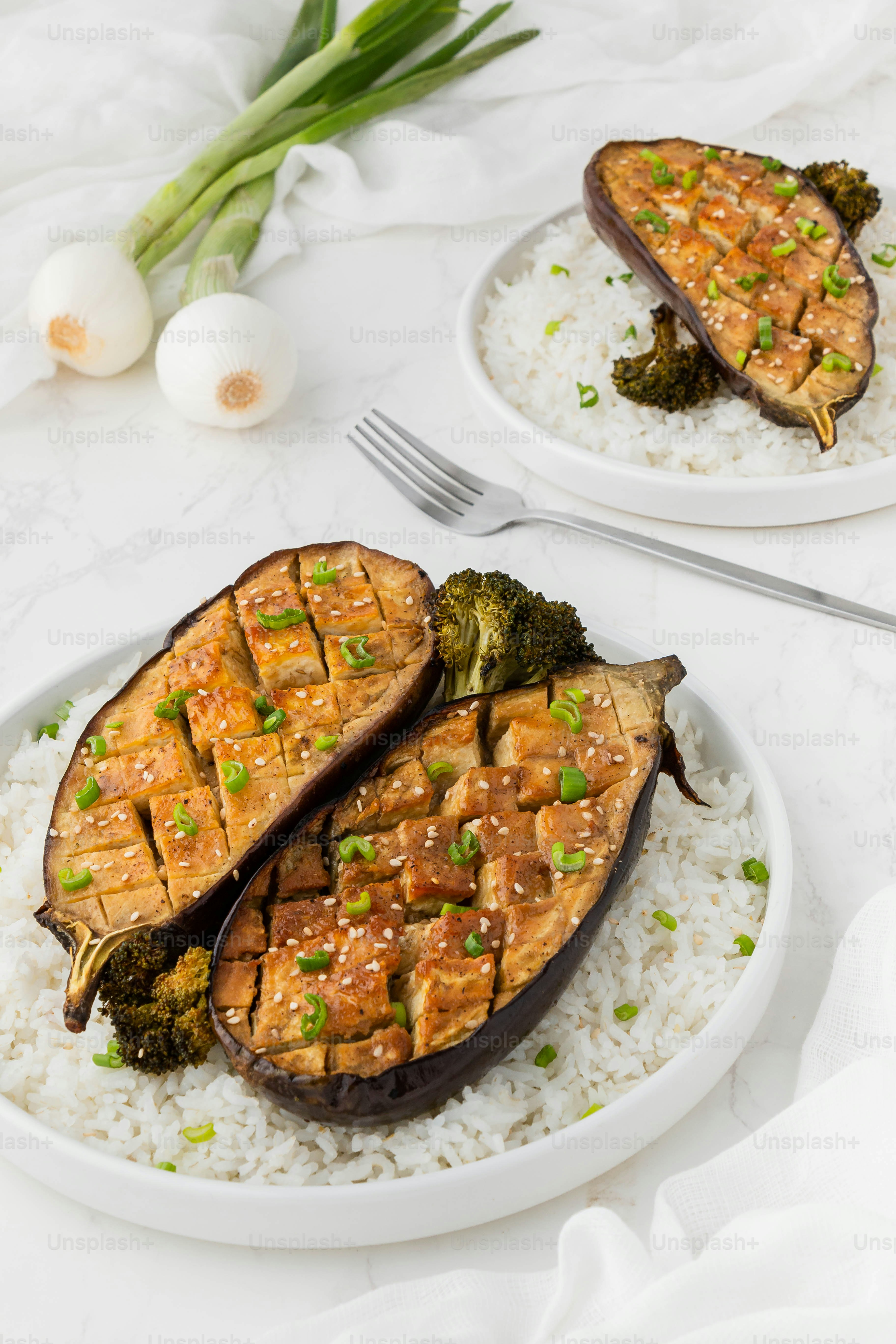 two plates of food with broccoli and rice