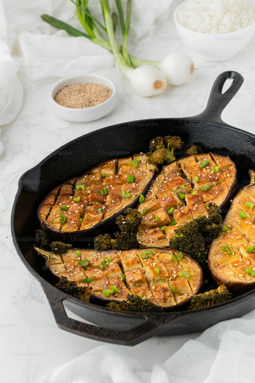 a pan filled with chicken and broccoli covered in sesame seeds