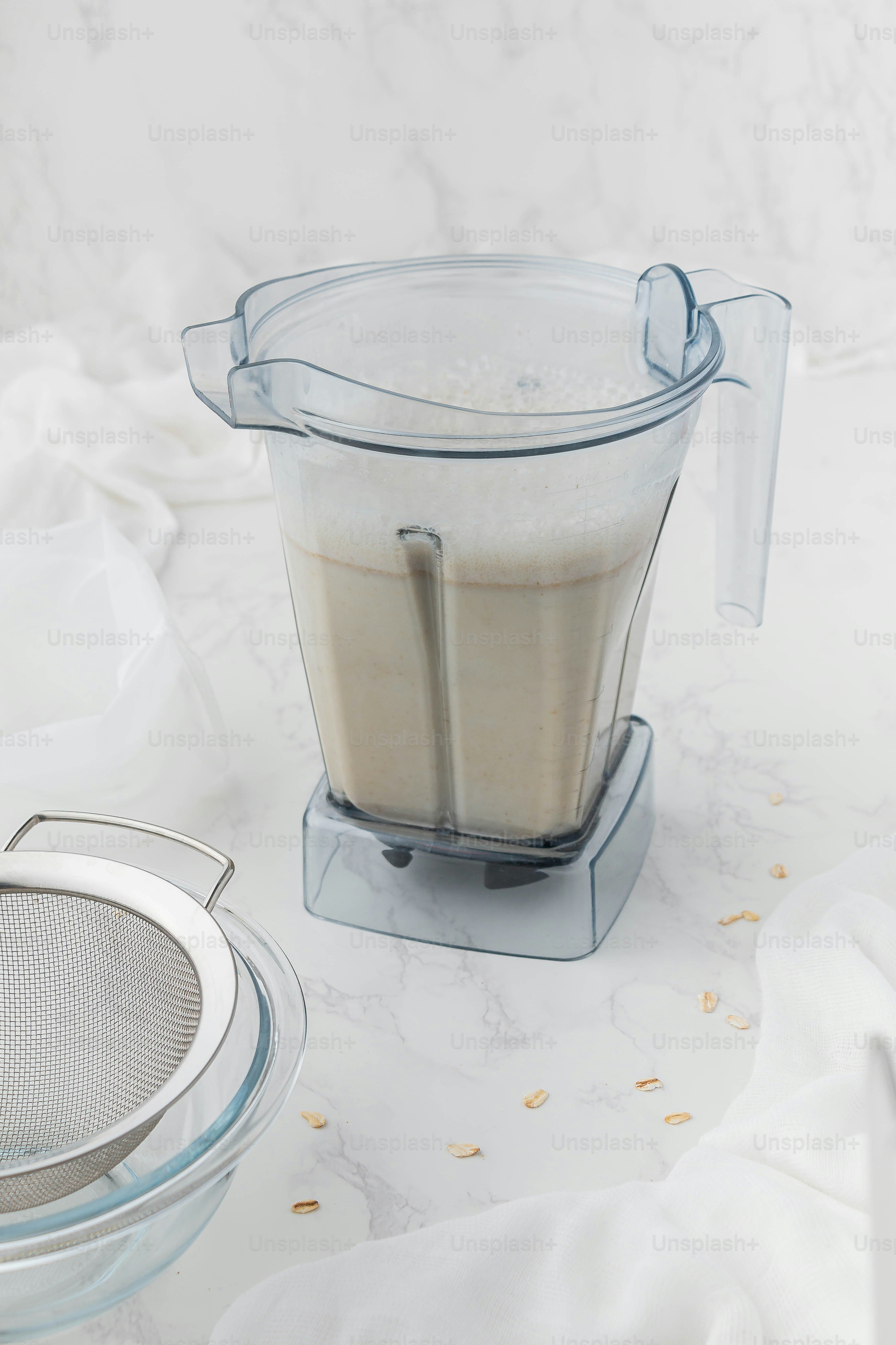 a blender filled with a liquid next to a strainer