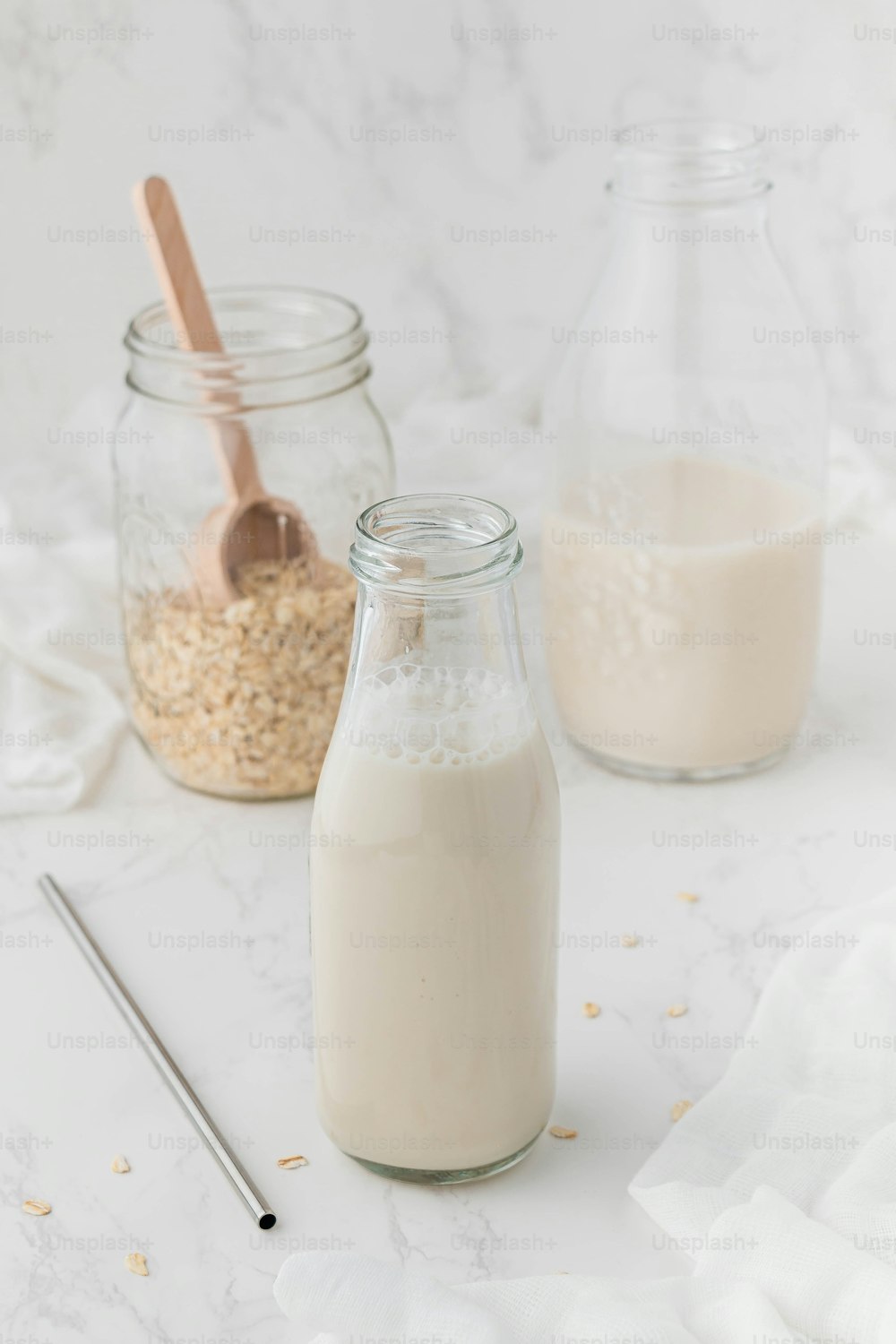 a glass jar filled with oatmeal next to a bottle of milk