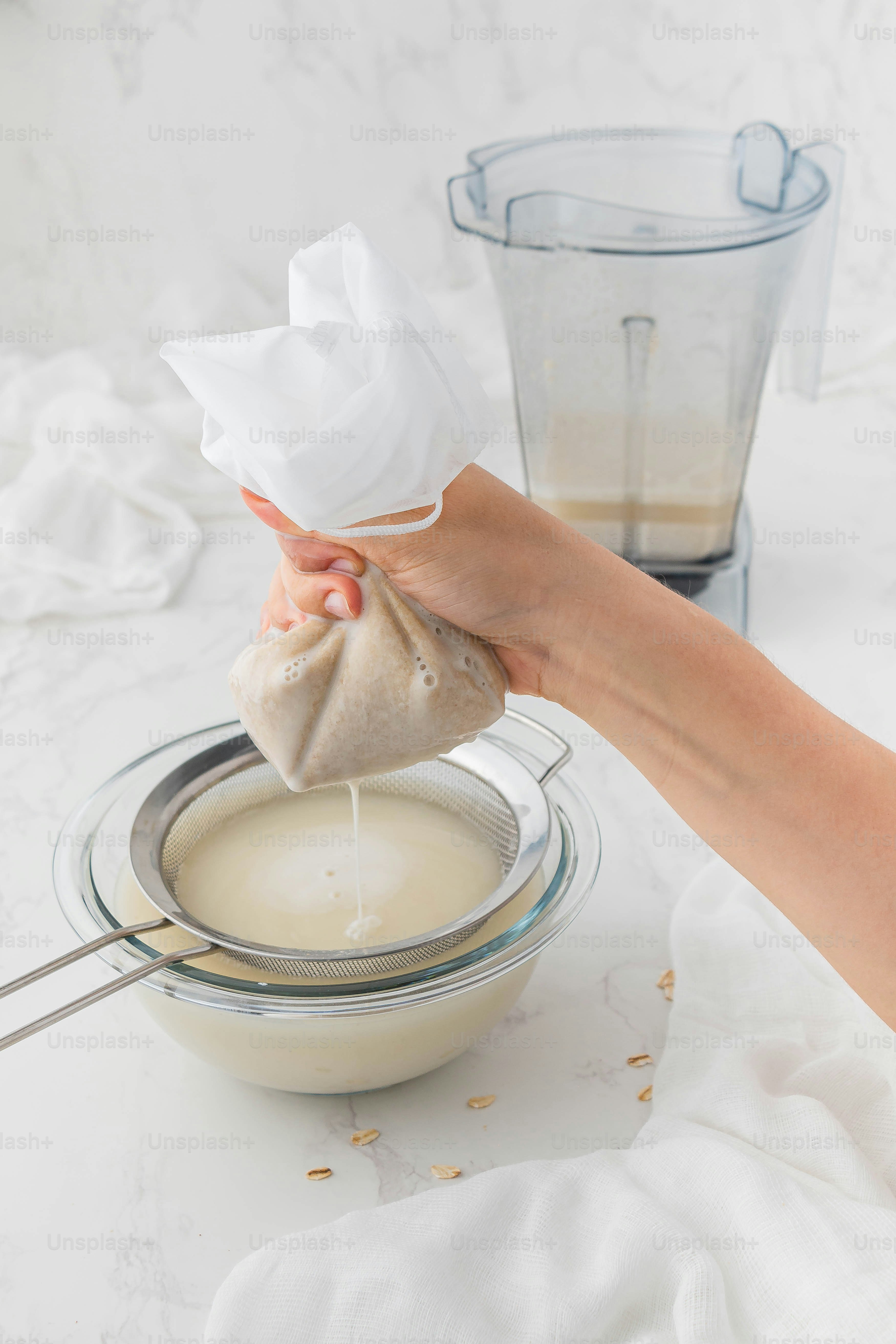 a person holding a cloth over a bowl of food