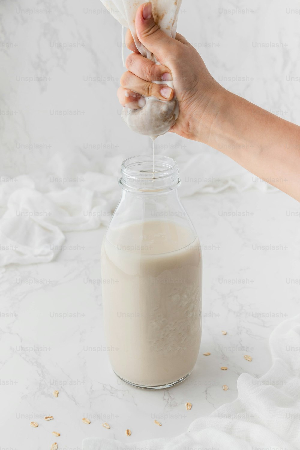 uma pessoa está derramando leite em um frasco de vidro