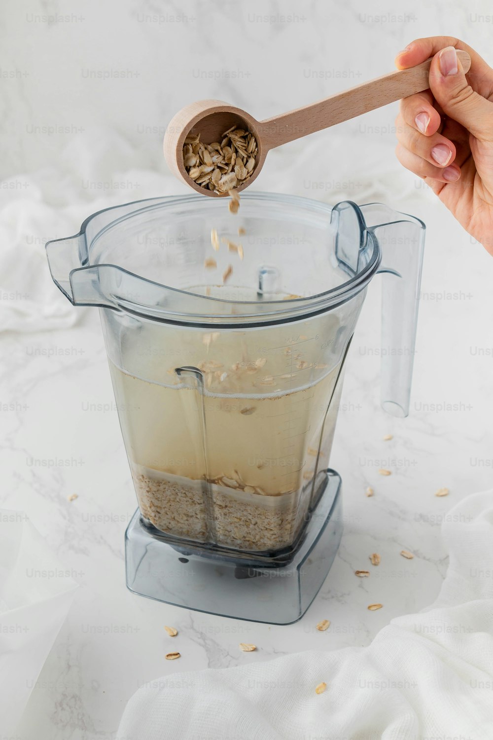 a blender filled with oats and a wooden spoon