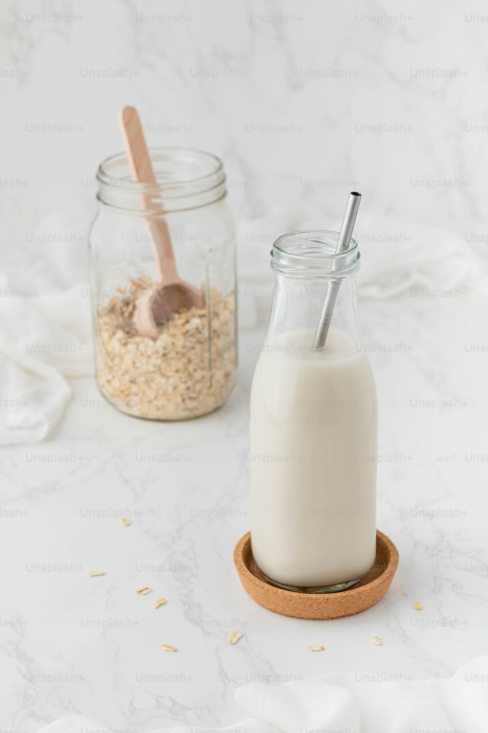a glass of milk next to a jar of oatmeal