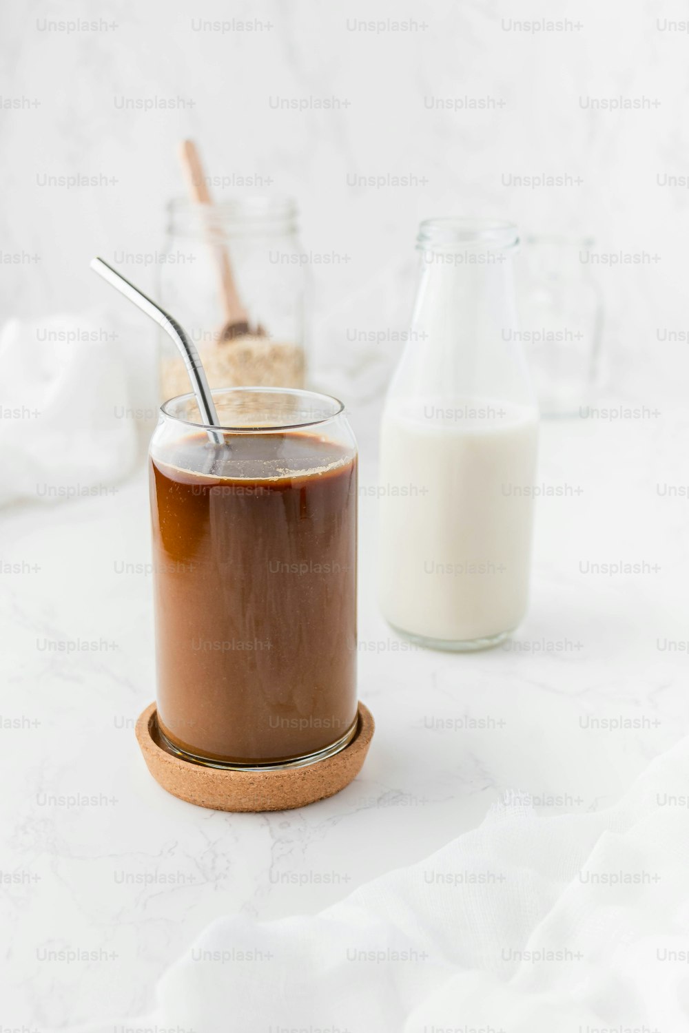 un frasco de pudín de chocolate junto a un vaso de leche
