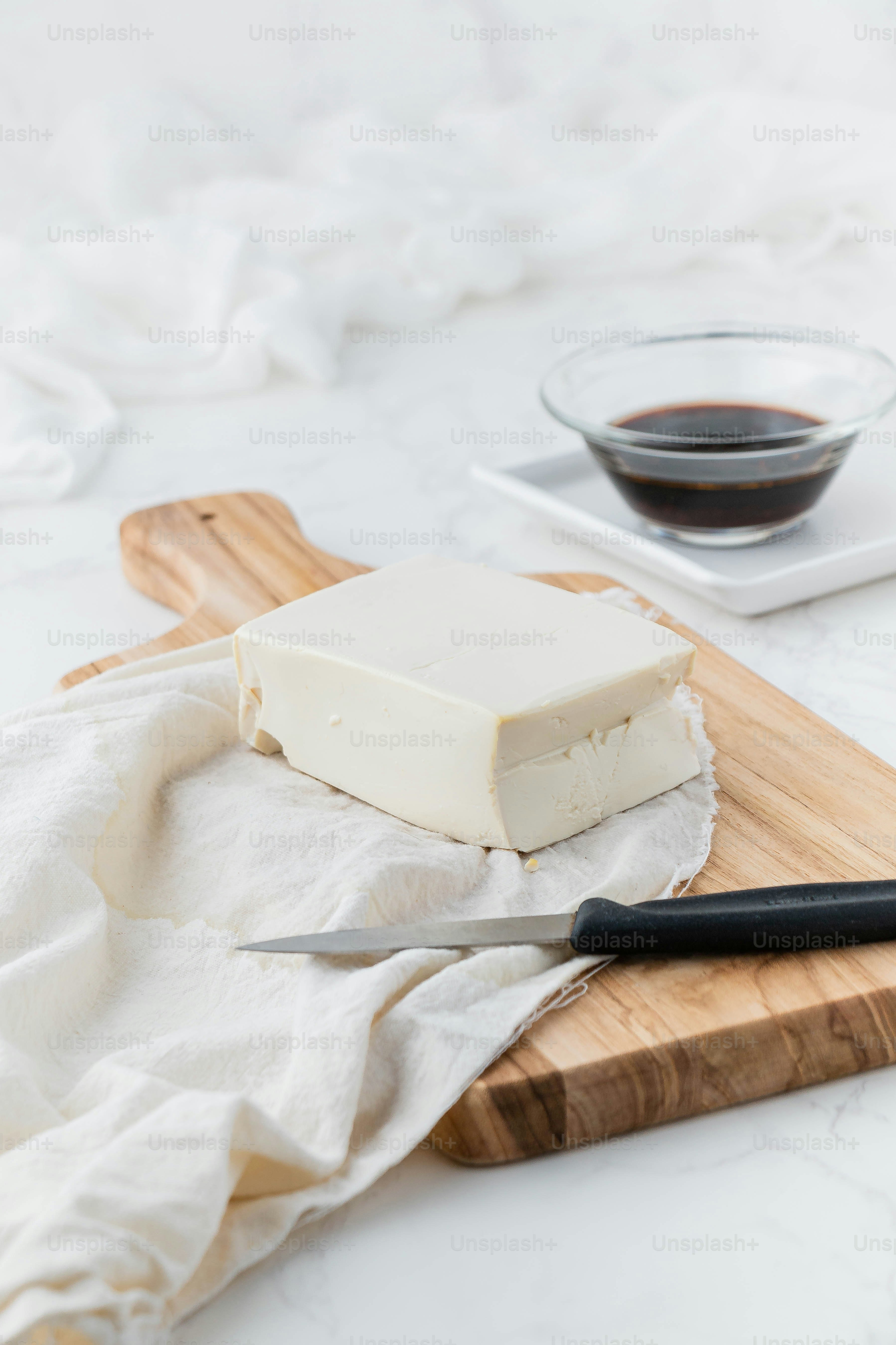a block of tofu sitting on top of a wooden cutting board