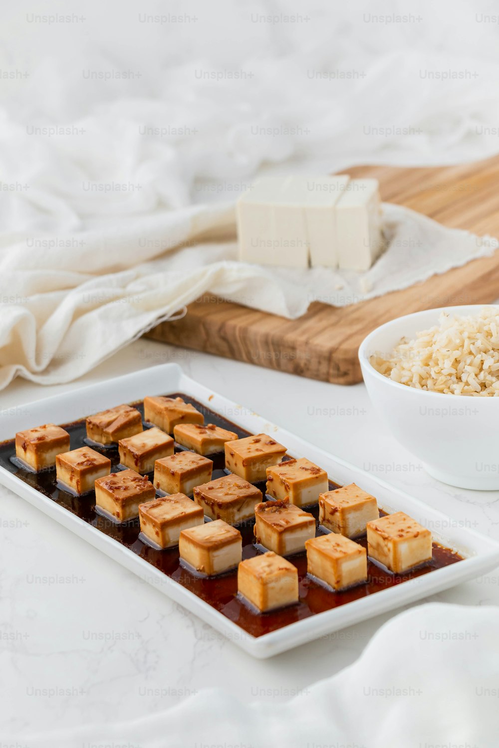 ein Teller Tofu neben einer Schüssel Reis