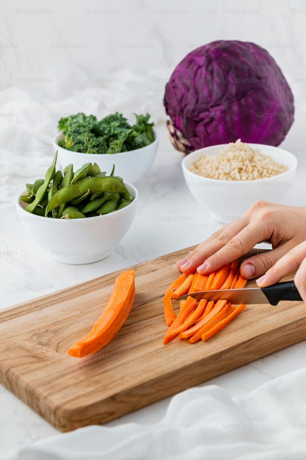 a person cutting up carrots on a cutting board