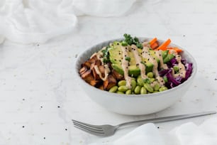a white bowl filled with vegetables and dressing