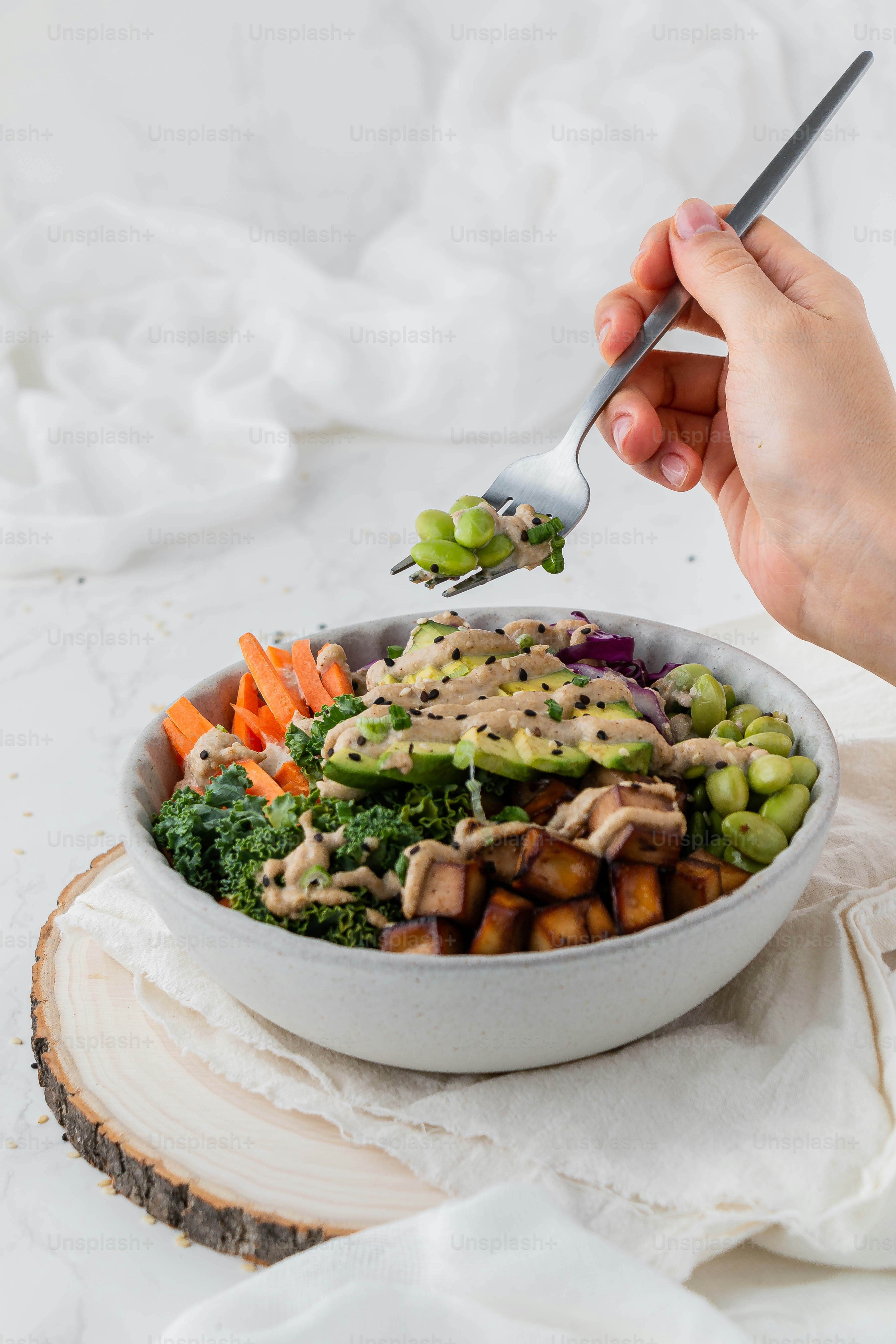 eine Person, die eine Gabel über eine Schüssel mit Essen hält