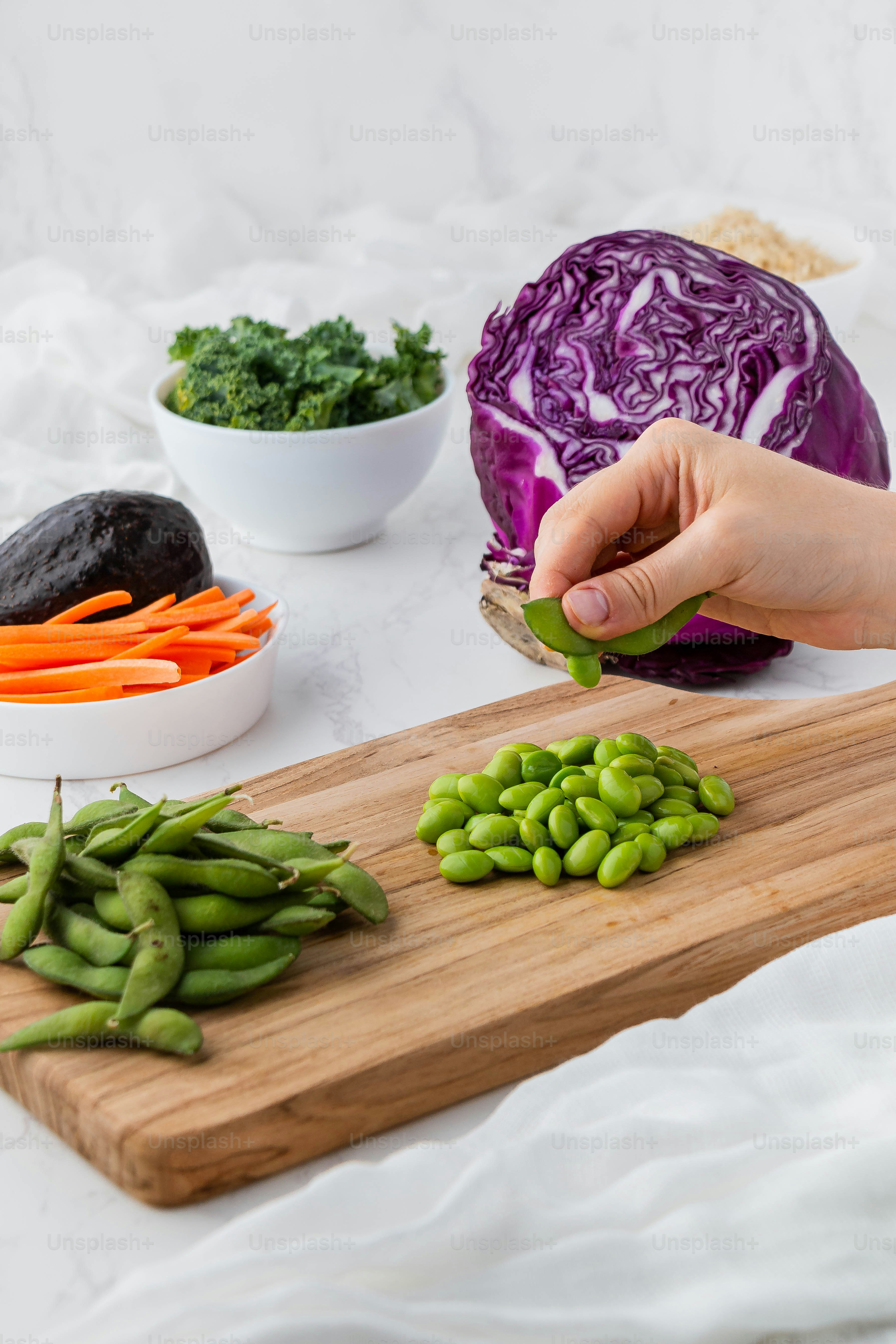eine Person, die Gemüse auf einem Schneidebrett schneidet