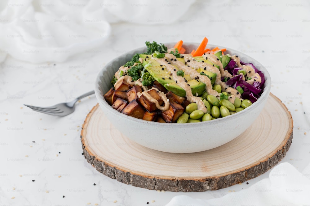 a white bowl filled with vegetables and dressing