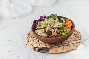 a wooden bowl filled with vegetables and rice