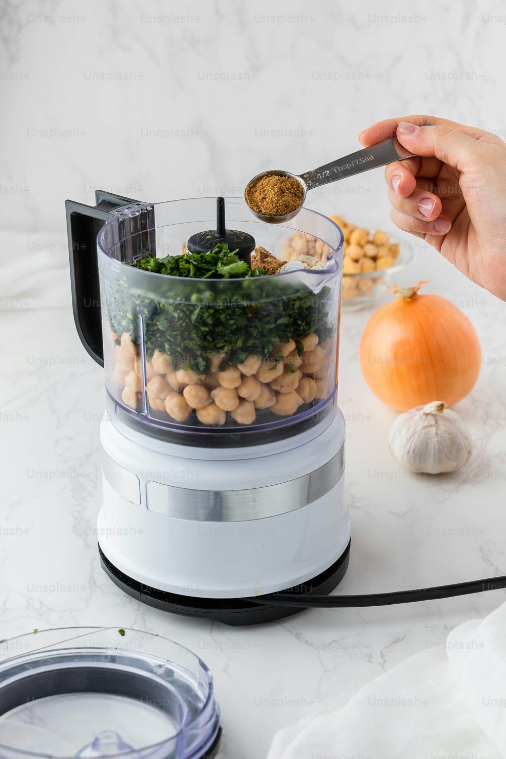 a person holding a spoon in a food processor