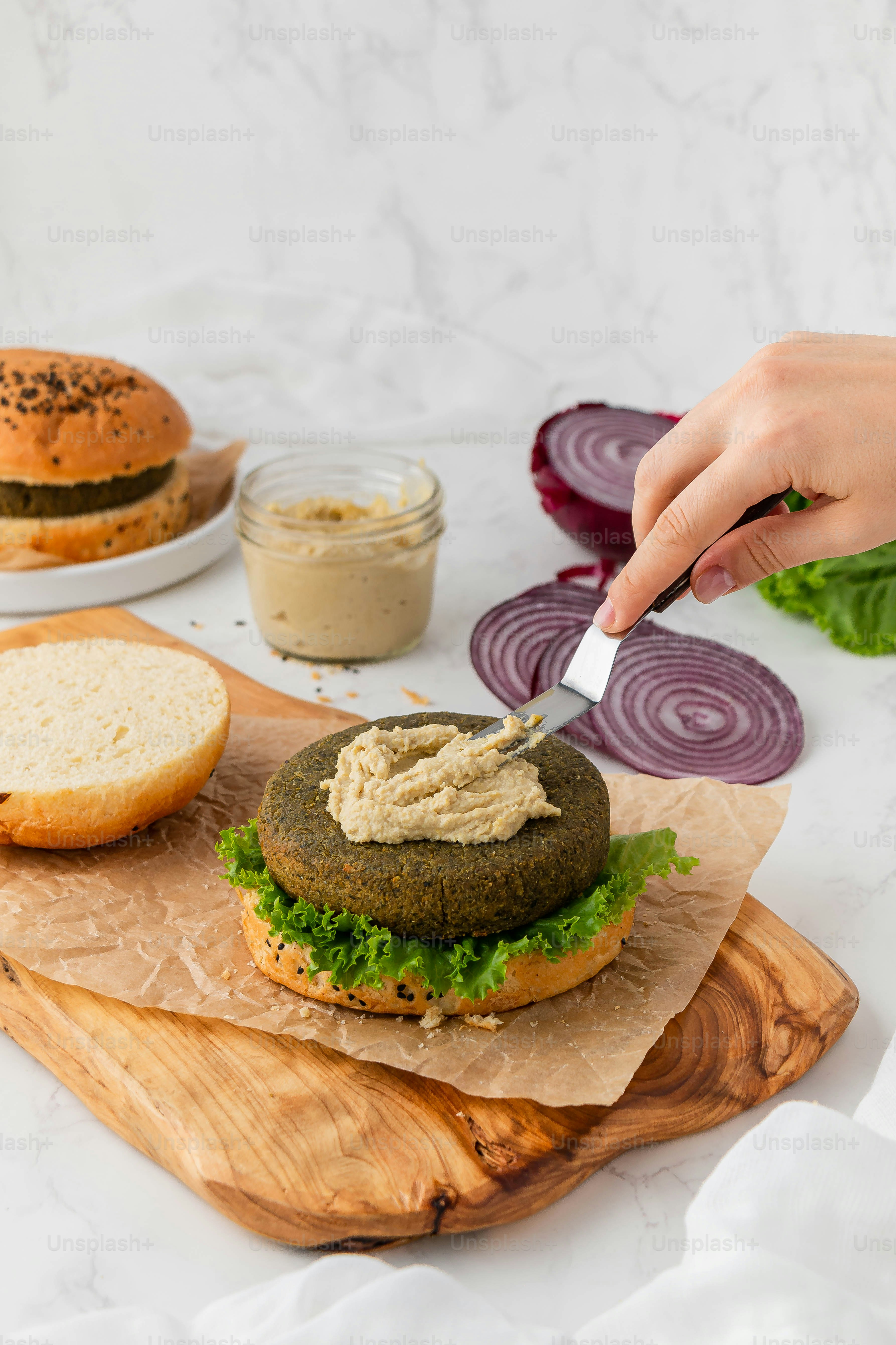 a person cutting up a sandwich on a cutting board