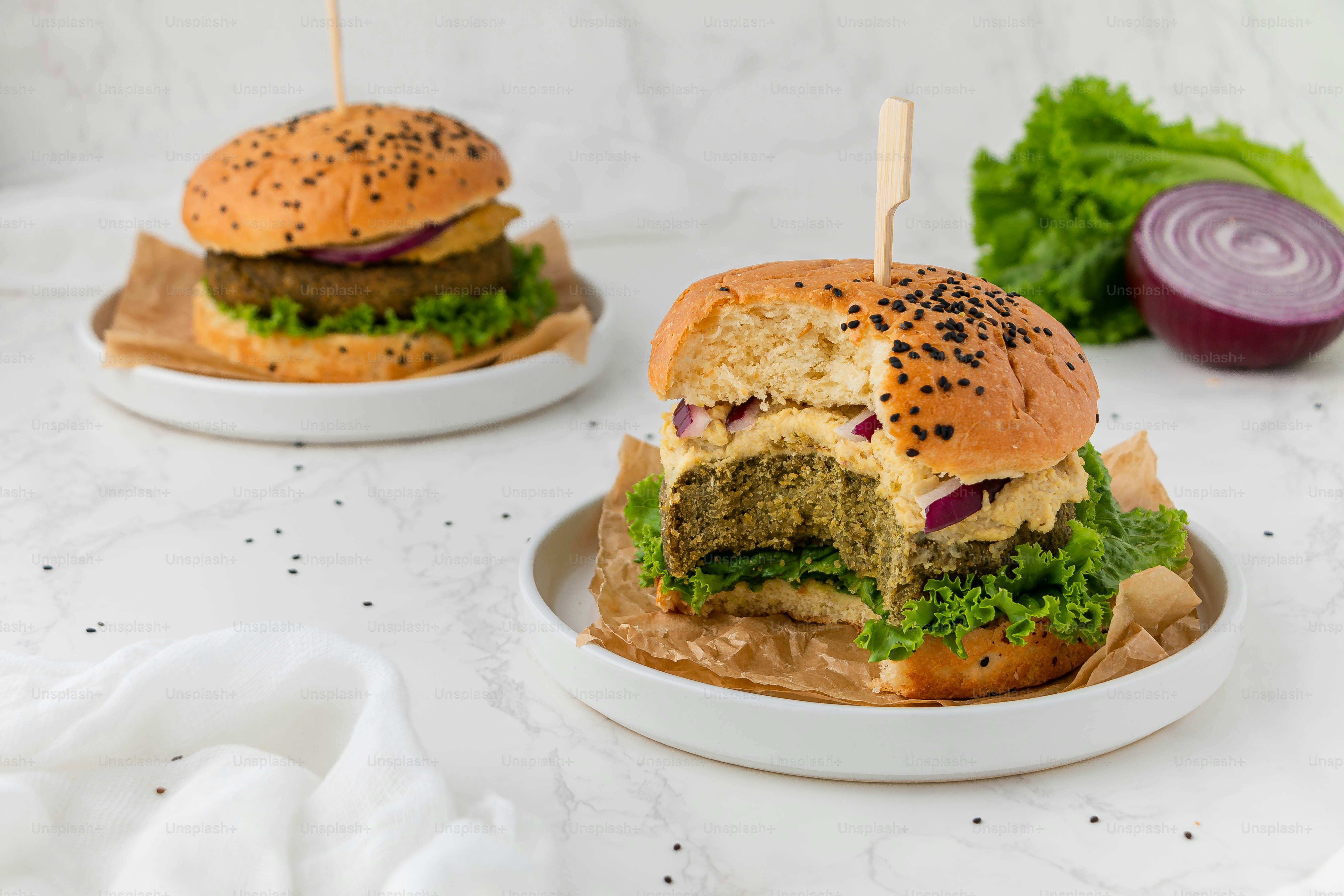 two burgers sitting on top of a white plate