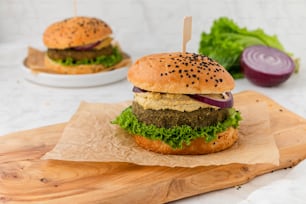 Una hamburguesa sentada encima de una tabla de cortar de madera