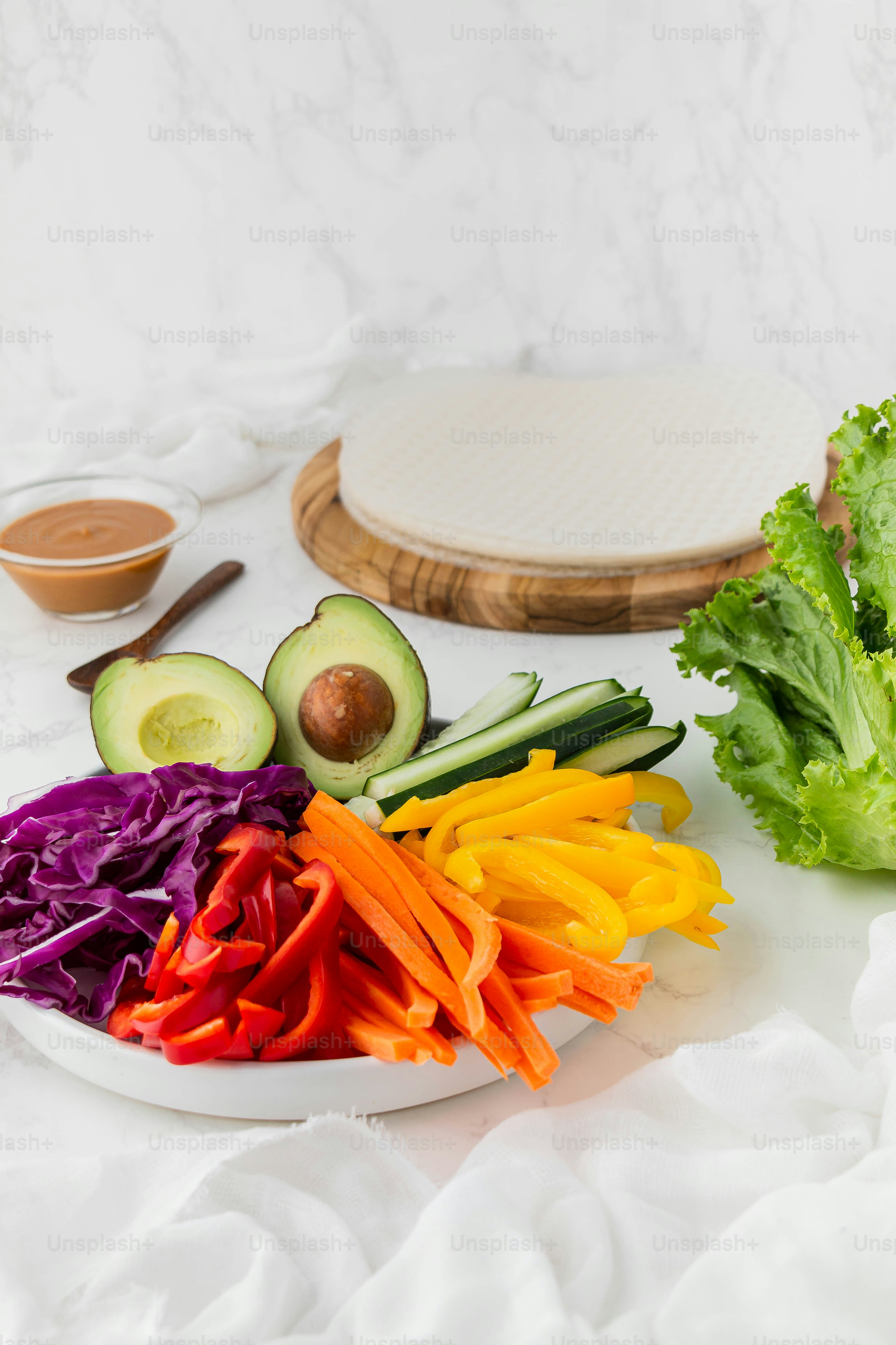 a white plate topped with vegetables next to a cutting board