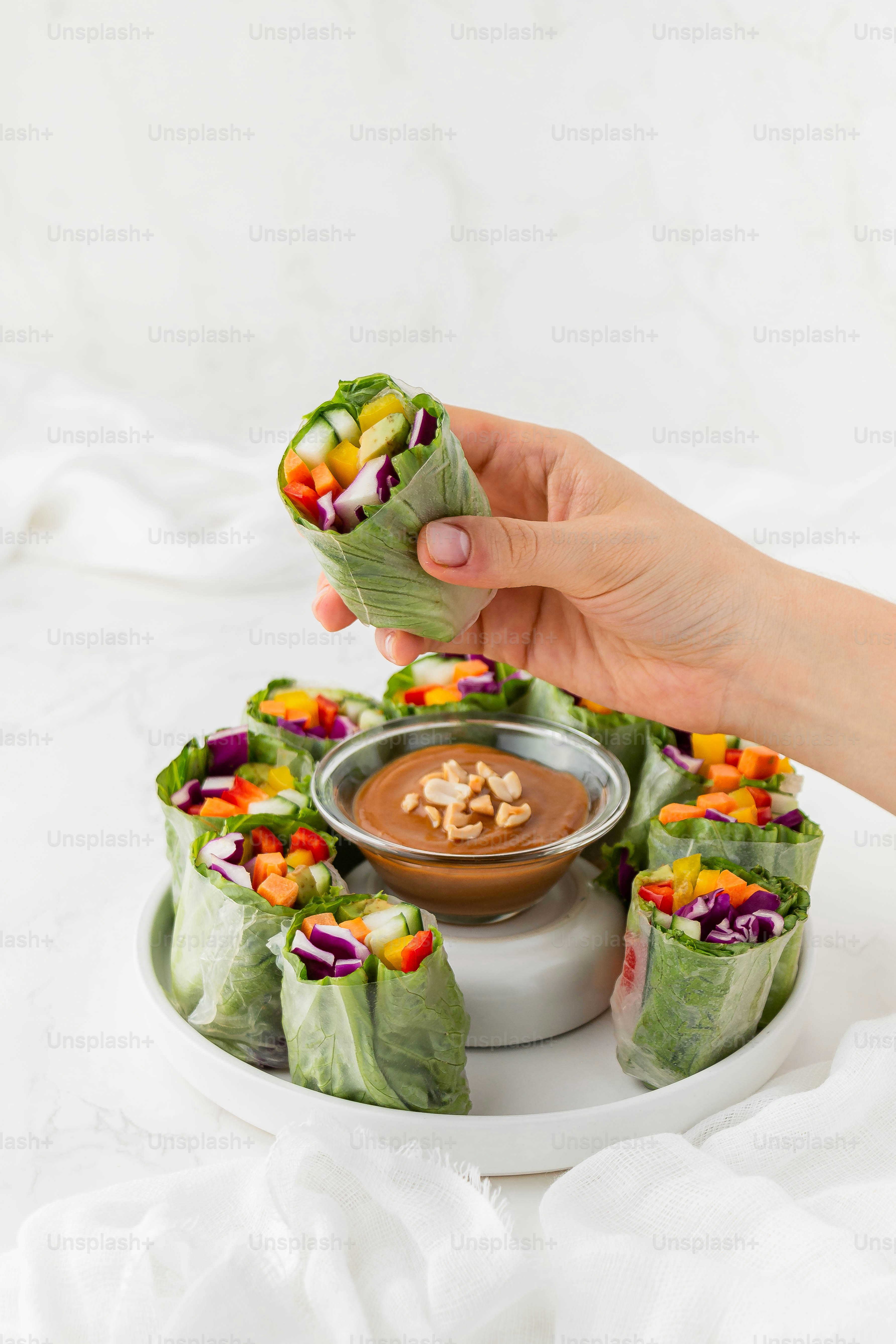 eine Person, die einen Teller mit Essen mit einer Dip-Sauce hält